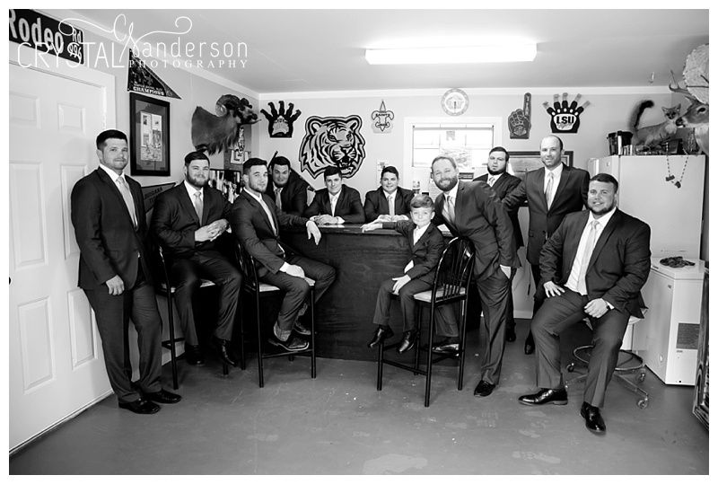 Groomsmen lounging in chairs along a hallway wall.