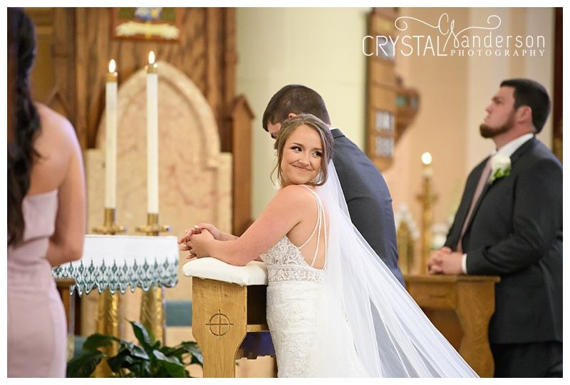 Intimate moments exchanged during a traditional Catholic church wedding ceremony.