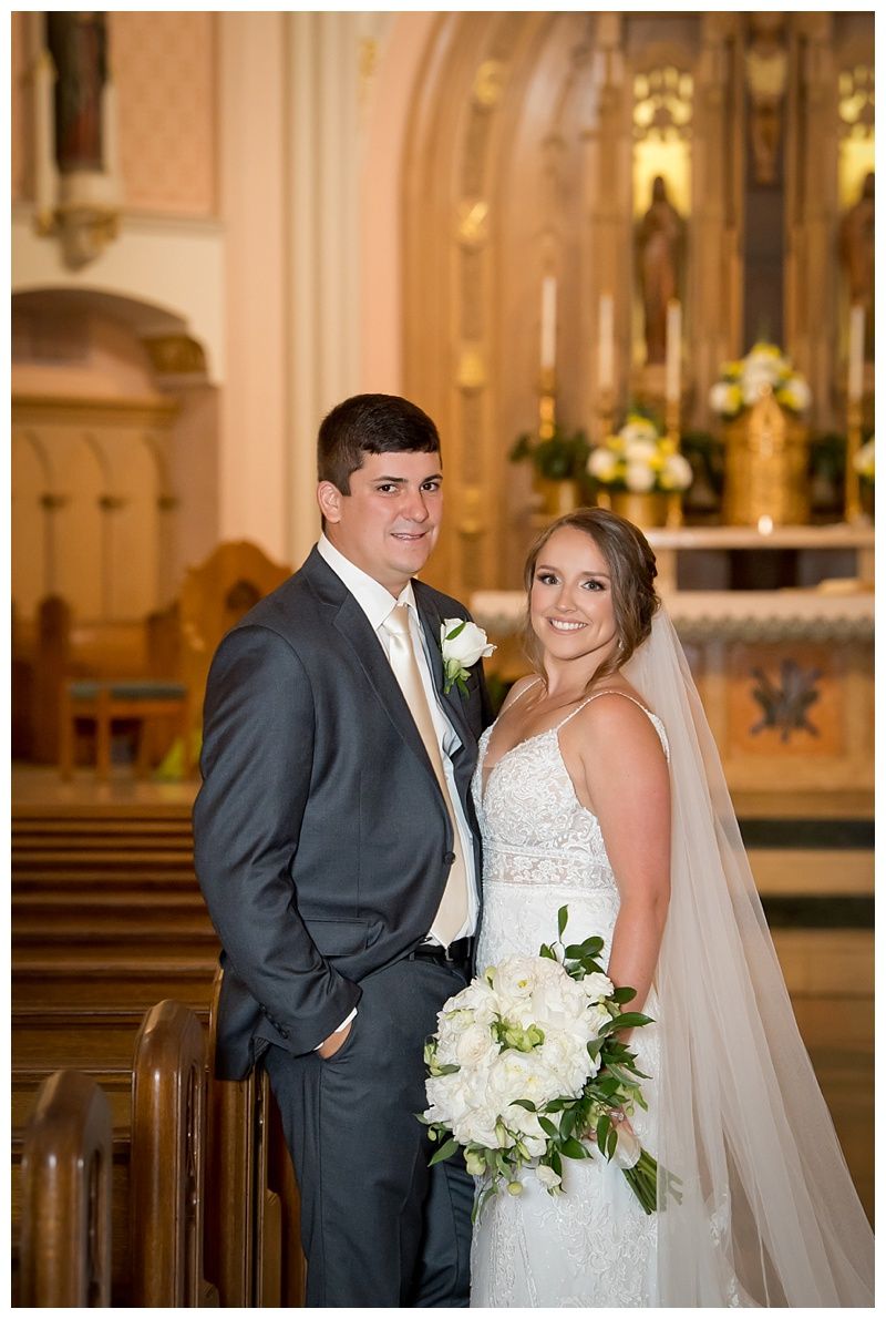 Elegant church wedding portraits featuring couple with white floral bouquet and formal attire.