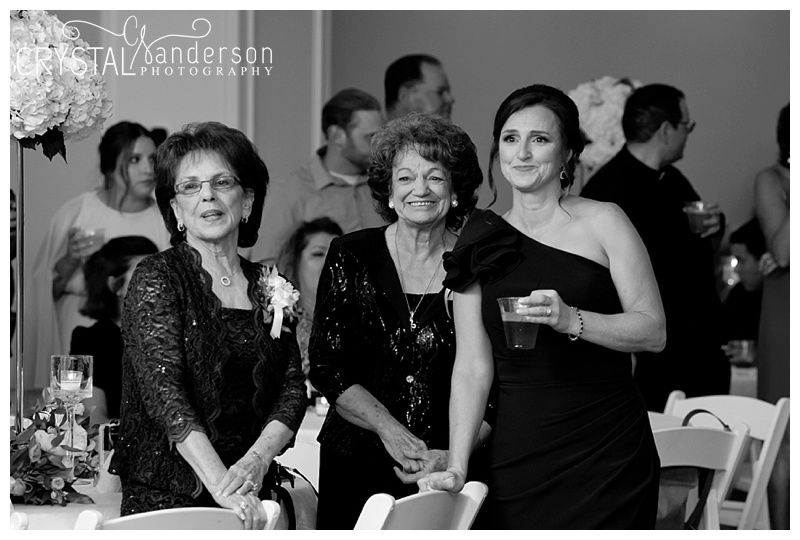 Black and white photo of wedding guests enjoying reception celebration.