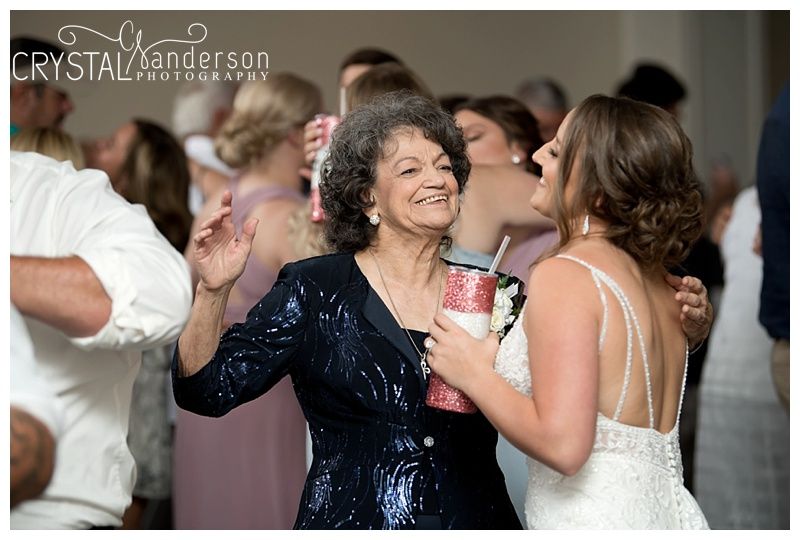 Wedding reception guests dance and celebrate on the dance floor during an evening celebration.