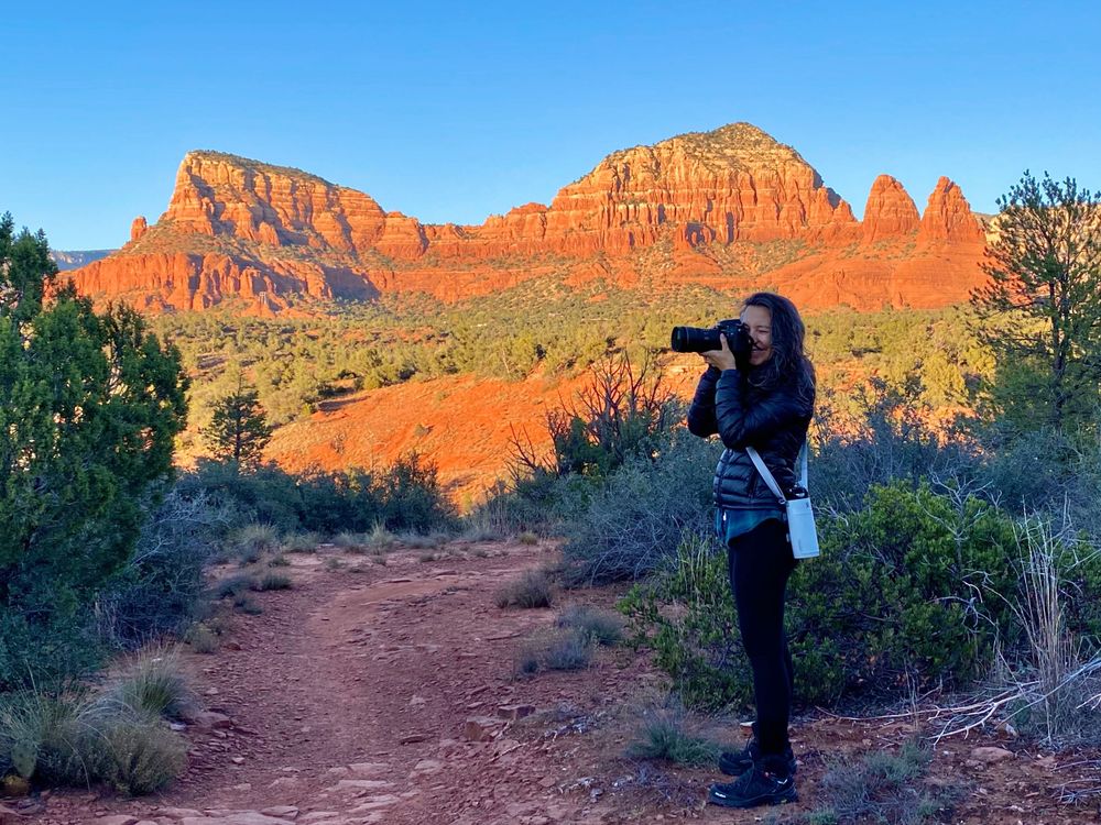 Photographer capturing red rock formations in Sedona desert landscape.