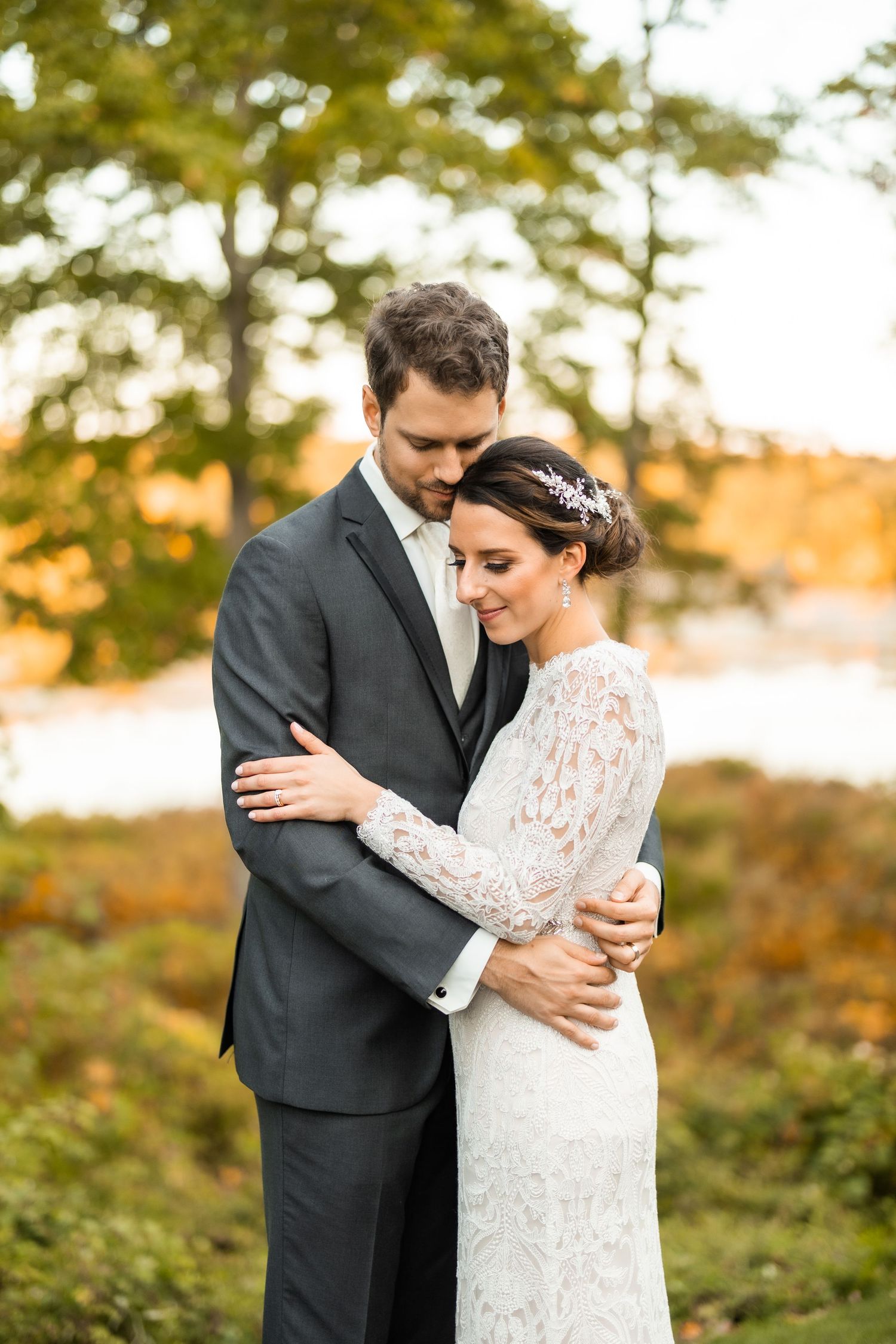 Intimate autumn wedding portrait with couple embracing outdoors.