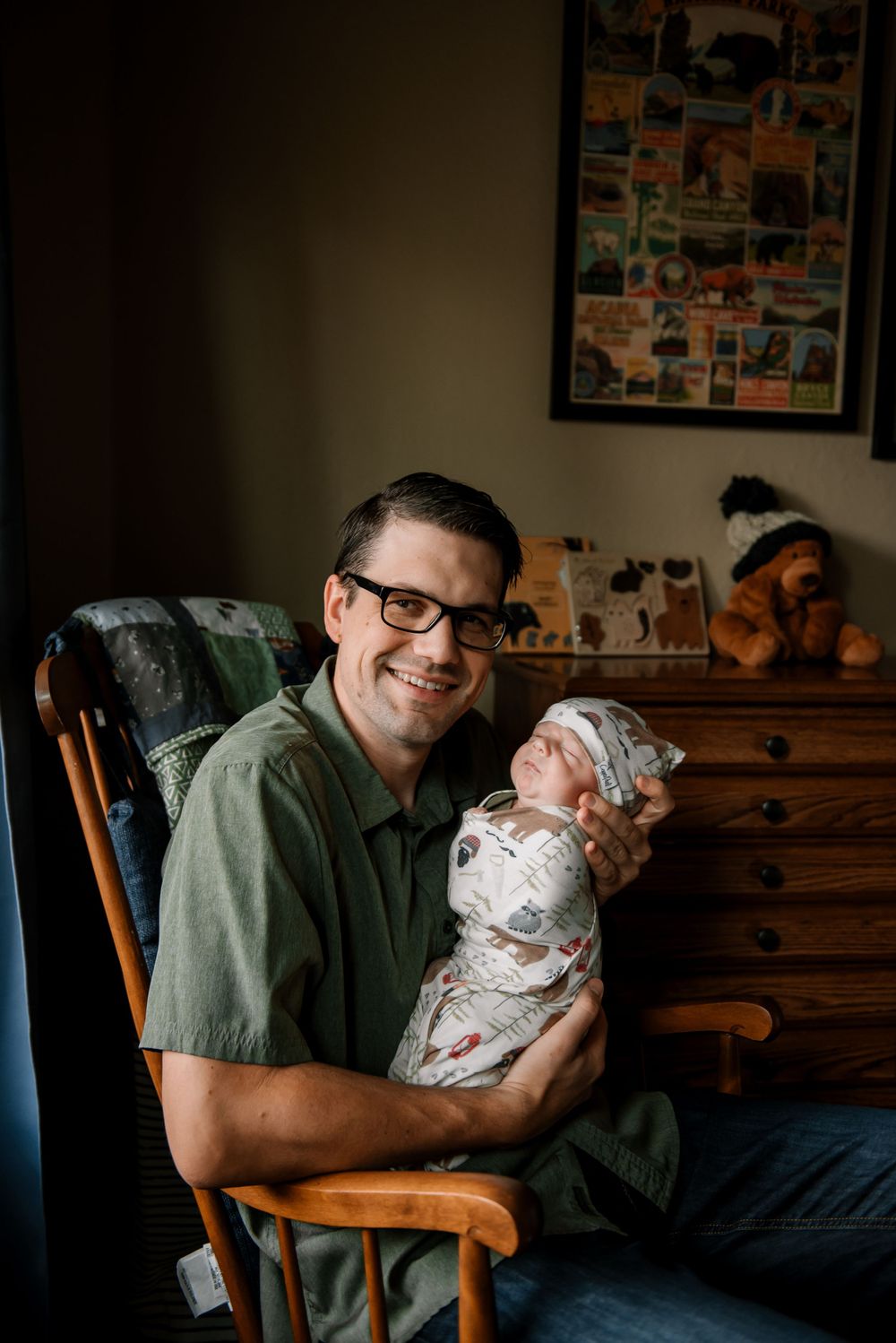 Tender moment with baby wrapped in floral swaddle blanket in nursery setting.