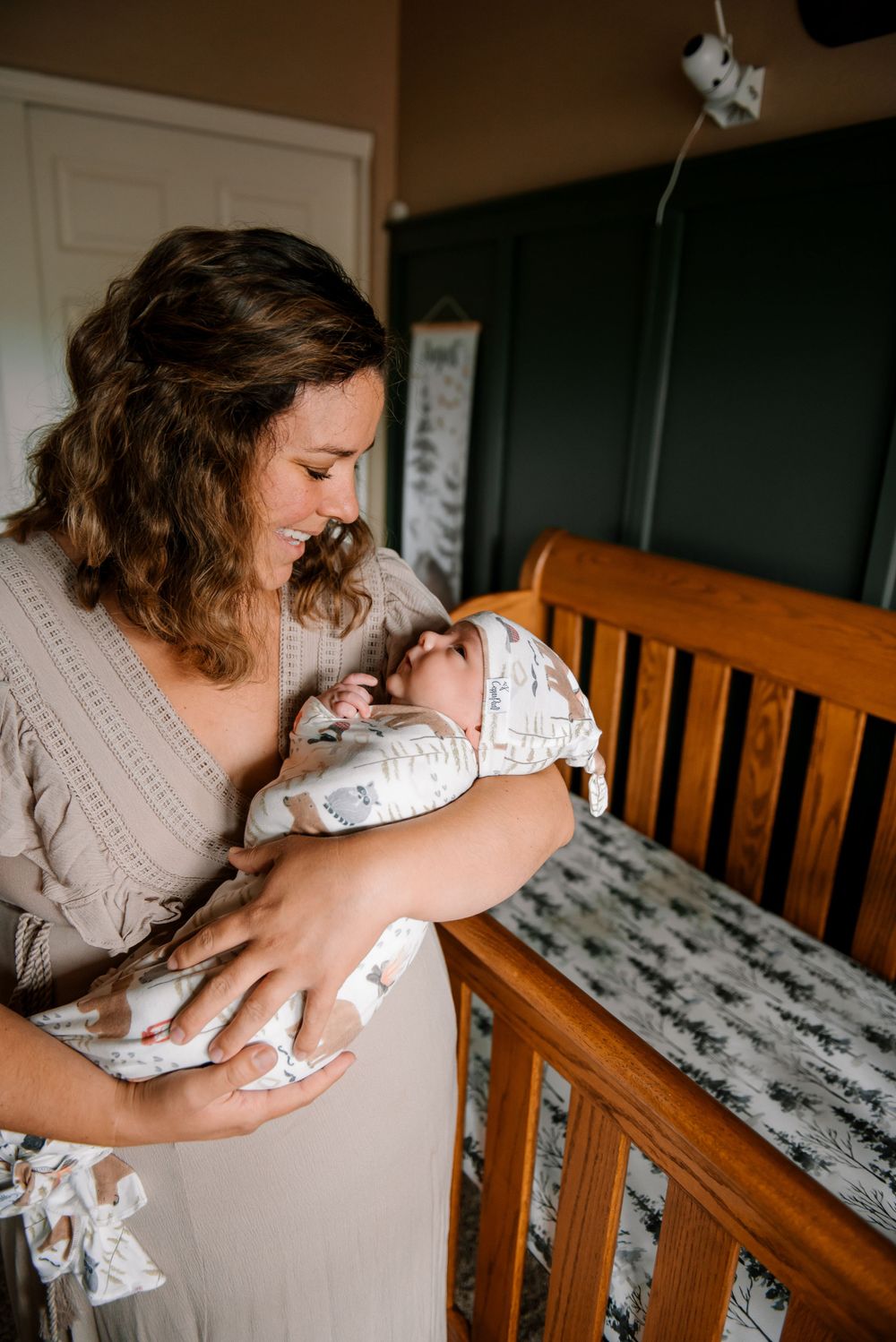 Tender moment in nursery with wooden crib and patterned bedding.