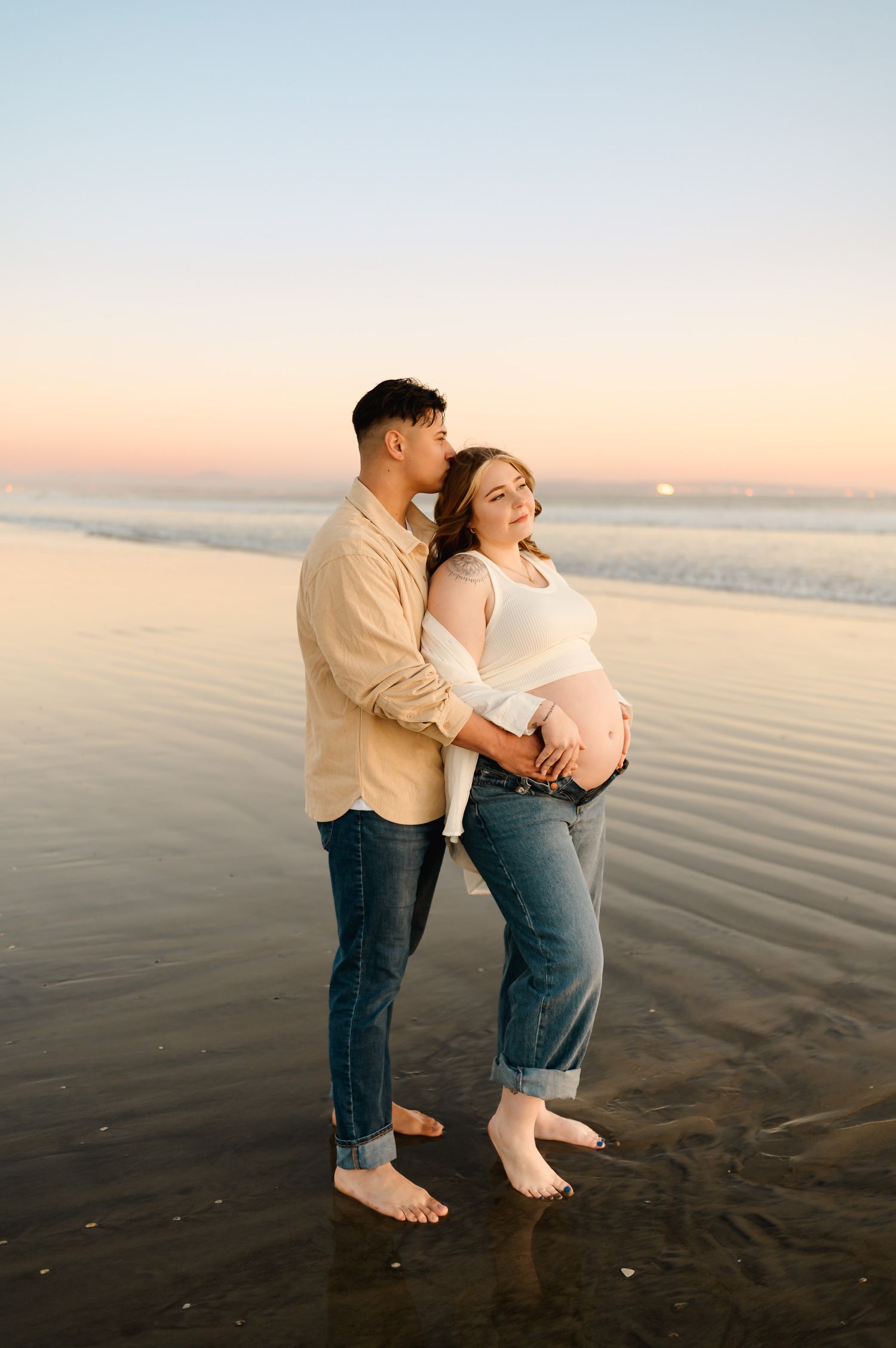 Oxnard Beach sunset maternity photoshoot by Santa Barbara maternity photographer of couple cuddling by the water