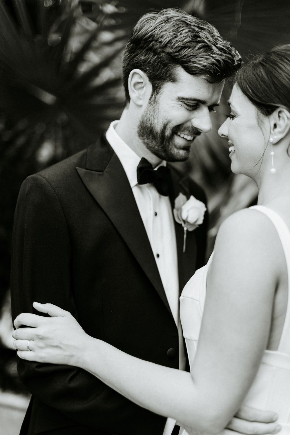 Romantic black and white portrait of newlyweds embracing and smiling together.