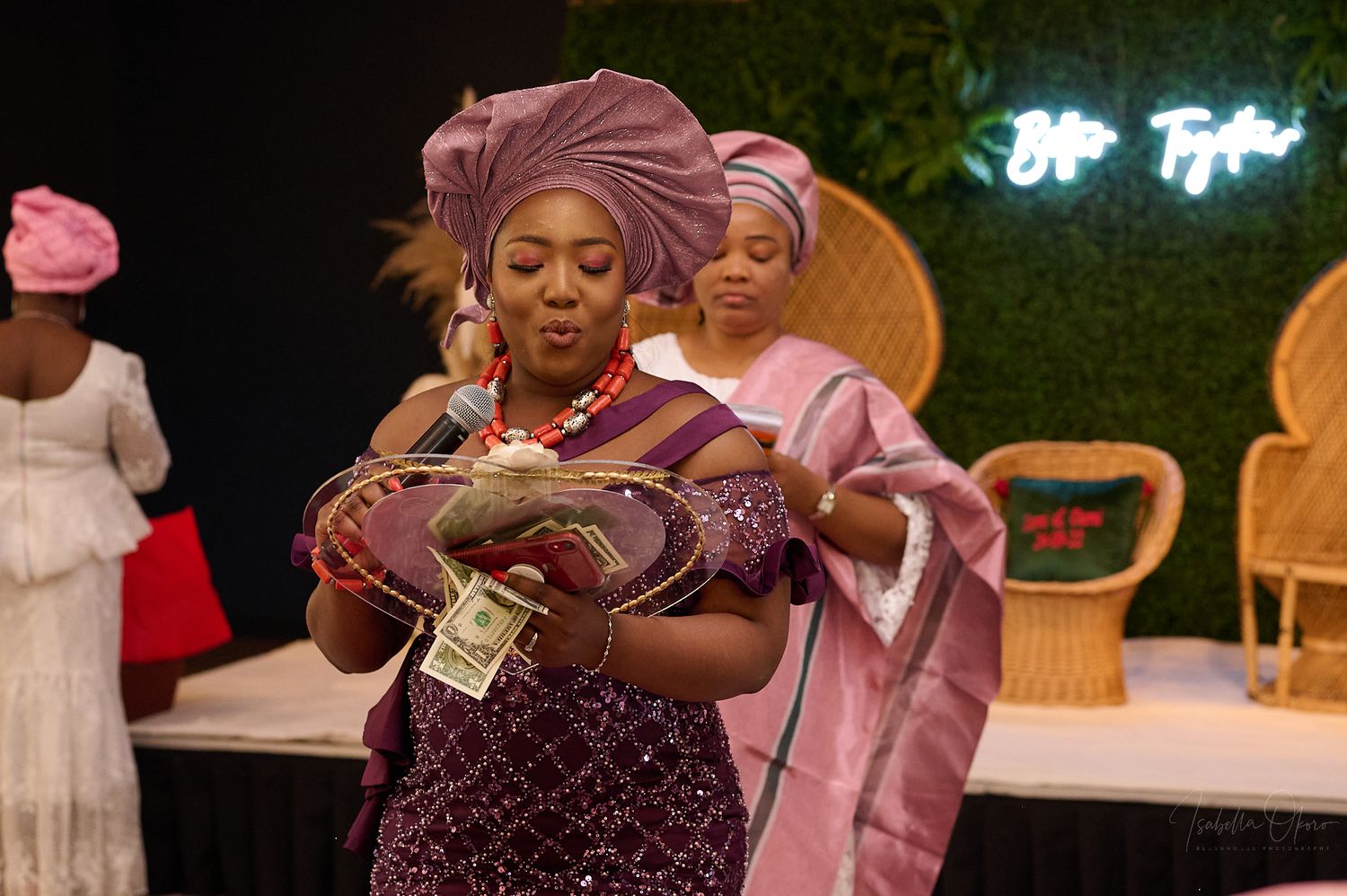 Traditional celebration with attendees in colorful headwraps and formal attire.