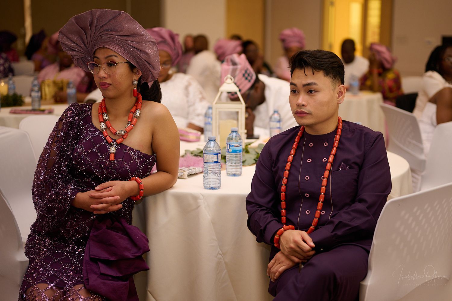 Wedding guests in formal cultural attire seated at a reception table.