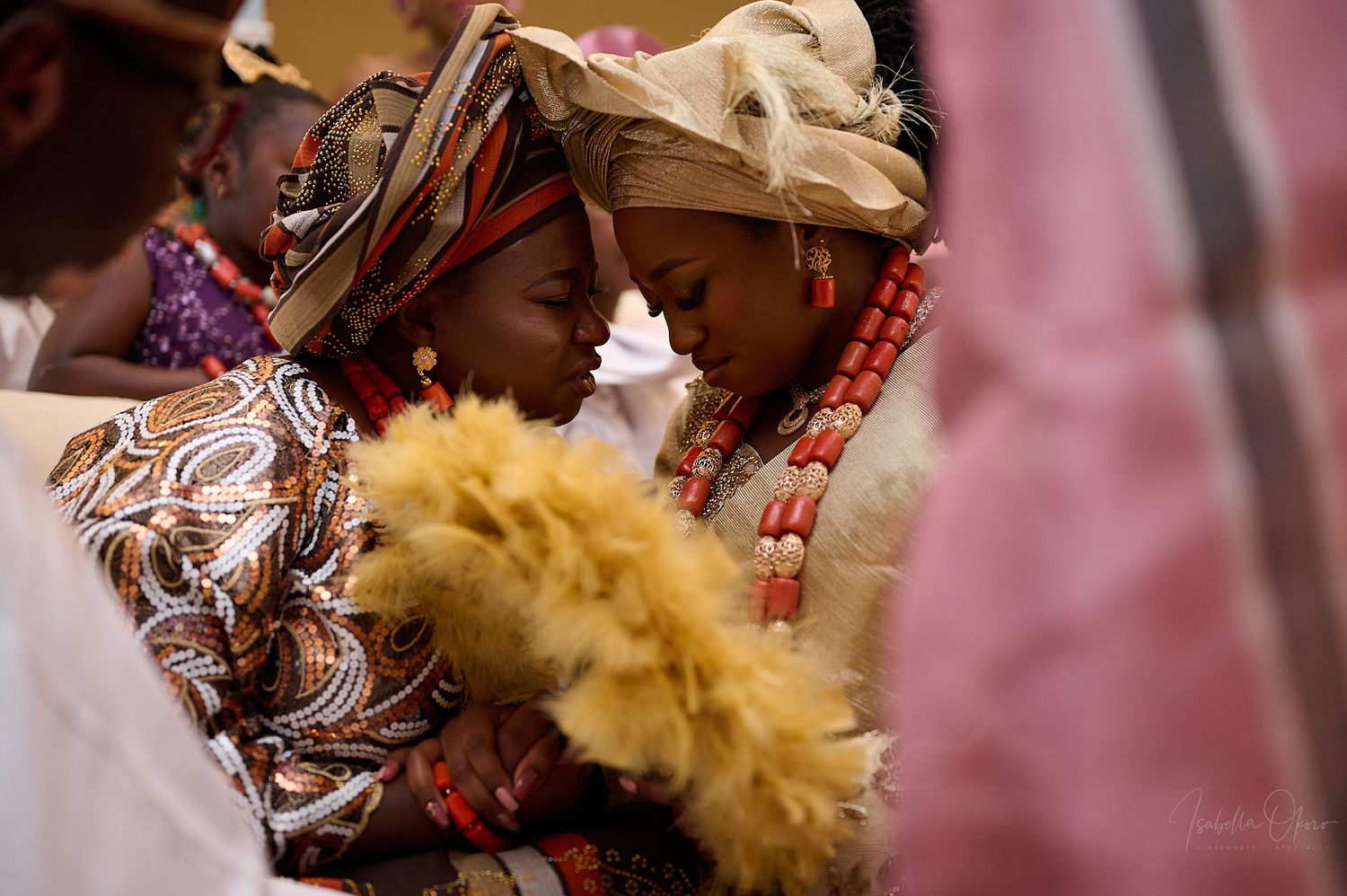 A couple in traditional African attire shares an intimate moment during a cultural celebration.