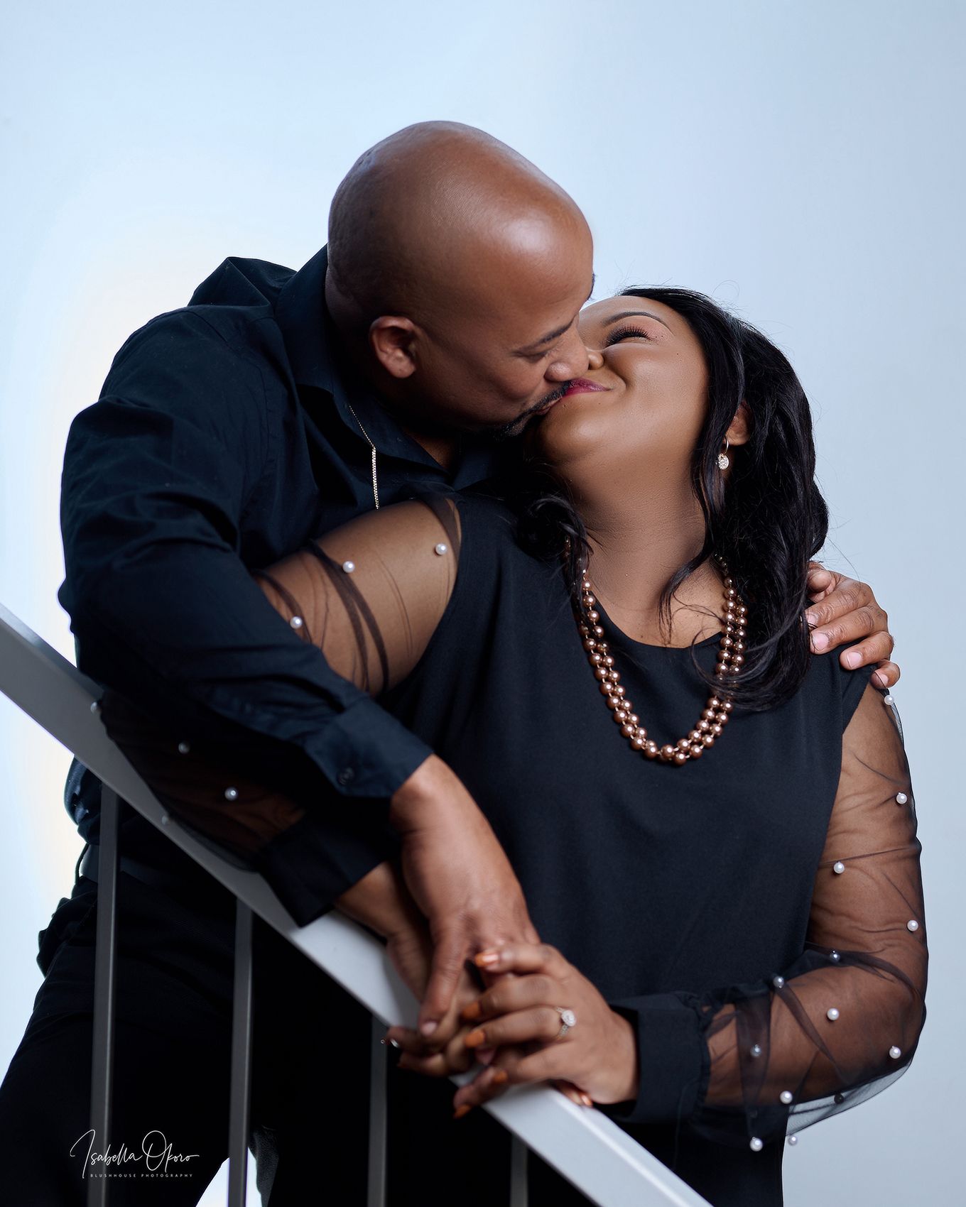 Intimate portrait of couple in black attire sharing a close moment.