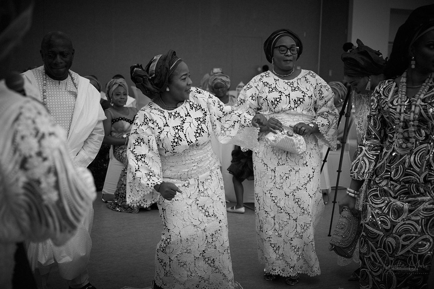 Black and white photo of traditional dancers in lace outfits performing at celebration.