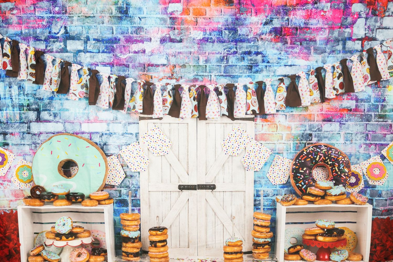 Donut party display with colorful graffiti wall backdrop and white wooden door centerpiece.