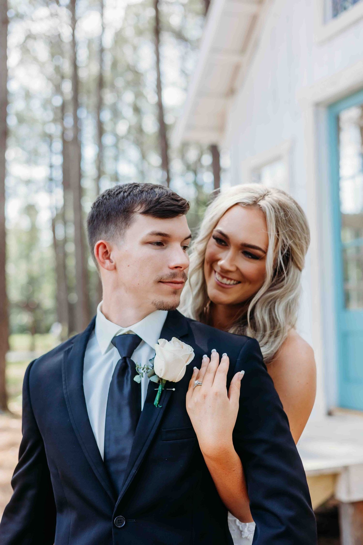 Outdoor wedding portraits with pine trees showing tender moments between couple in formal attire.