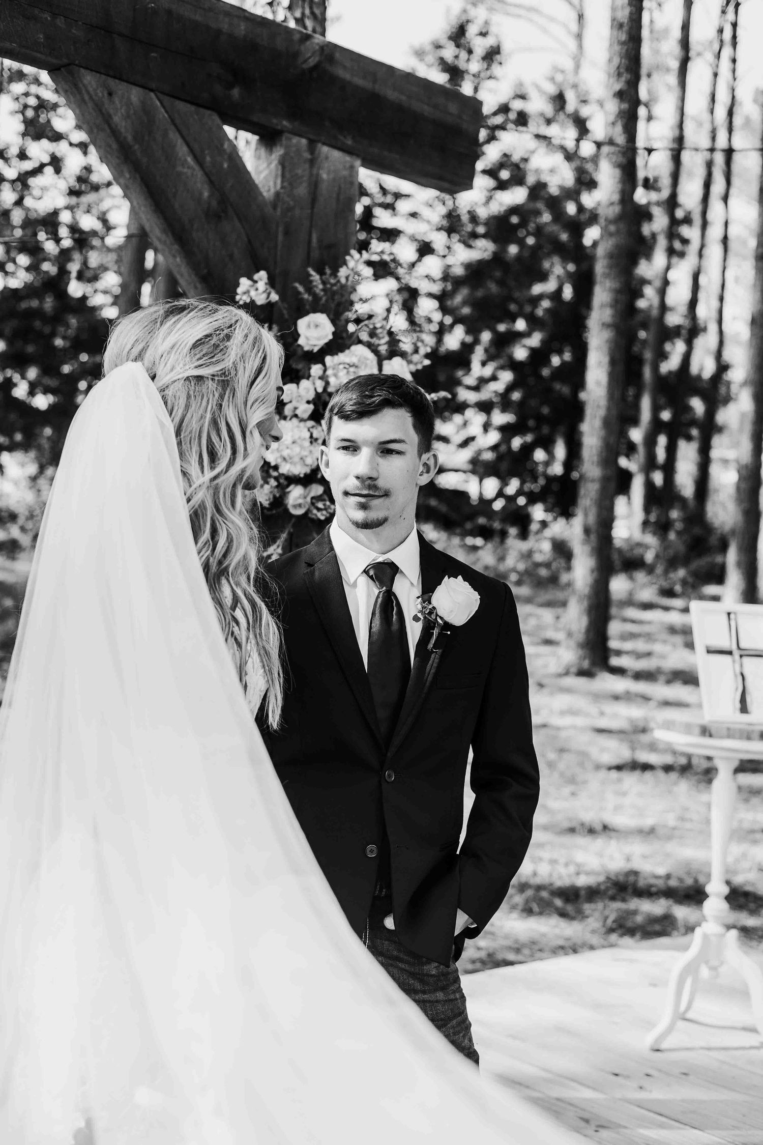 Black and white photos of wedding couple sharing intimate moments under forest canopy.
