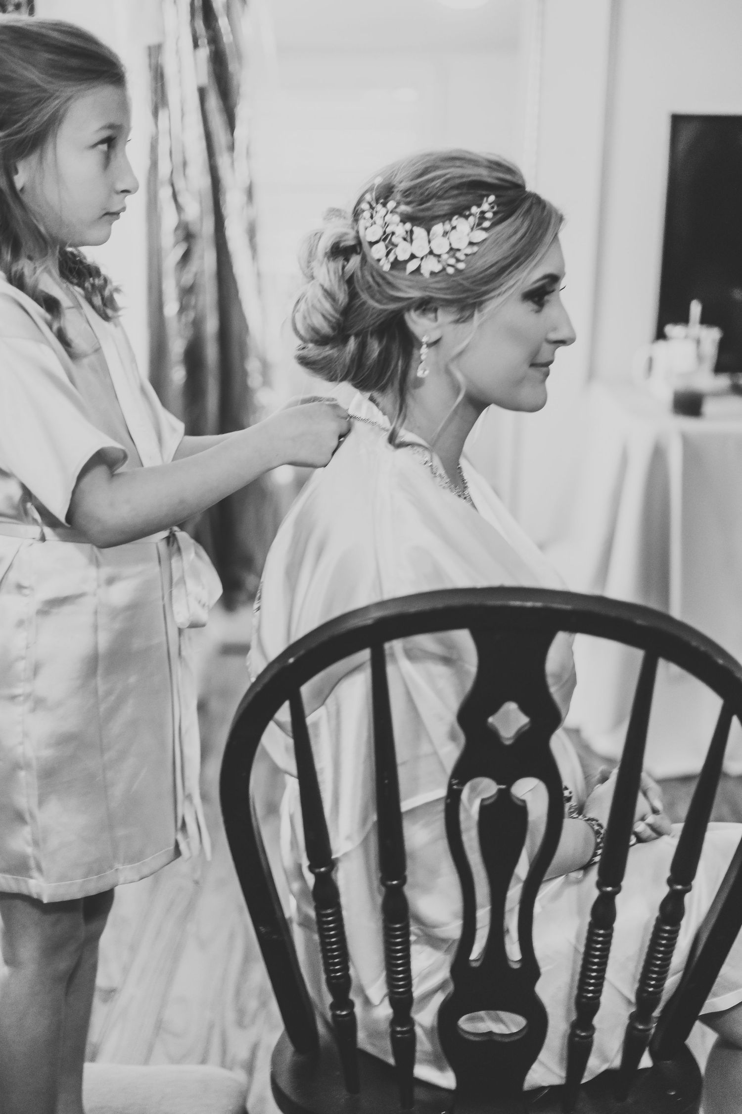 Black and white photo of wedding preparation with vintage wooden chair.