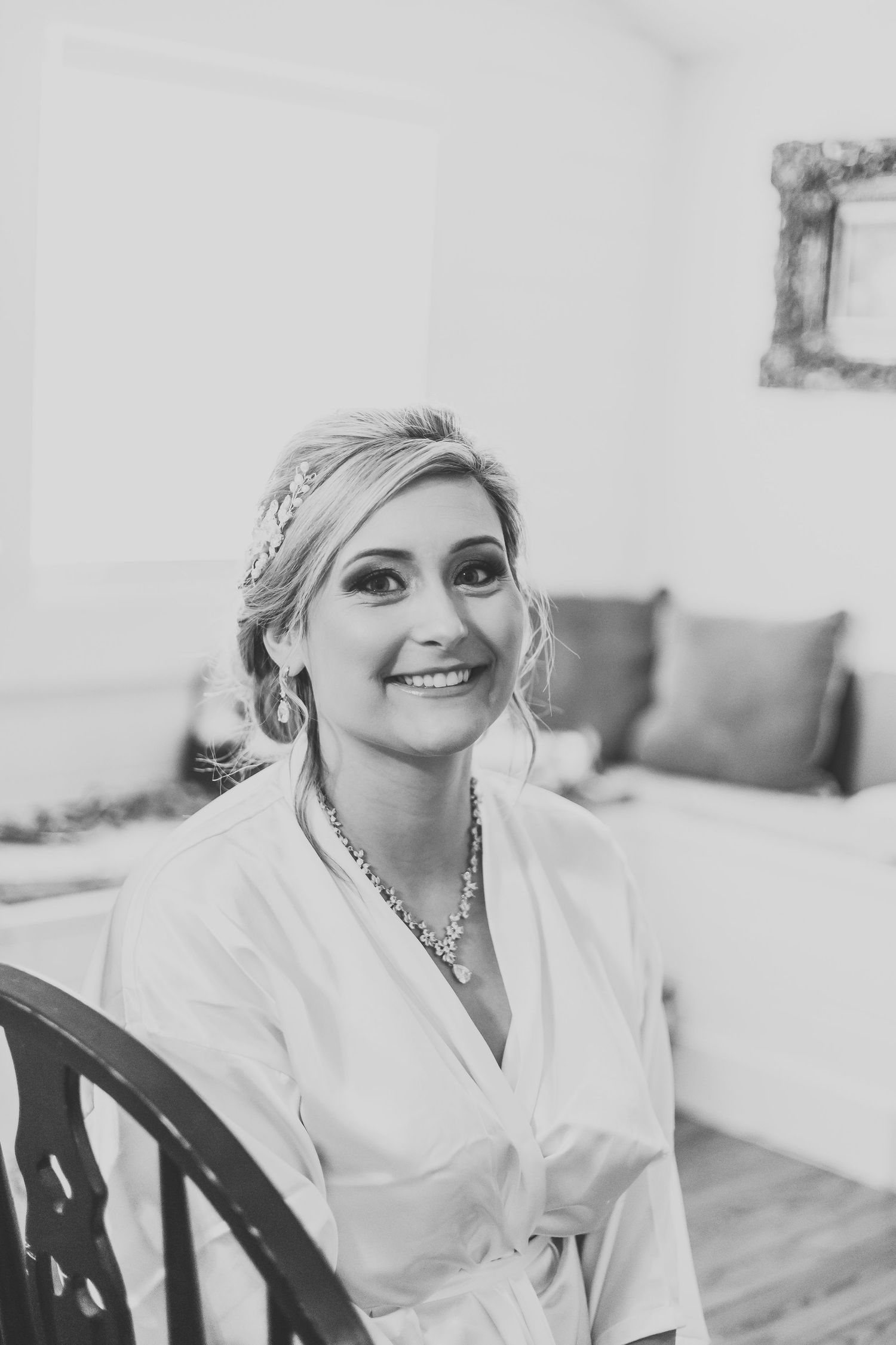 Candid getting ready moment in white robe with sparkly accessories.