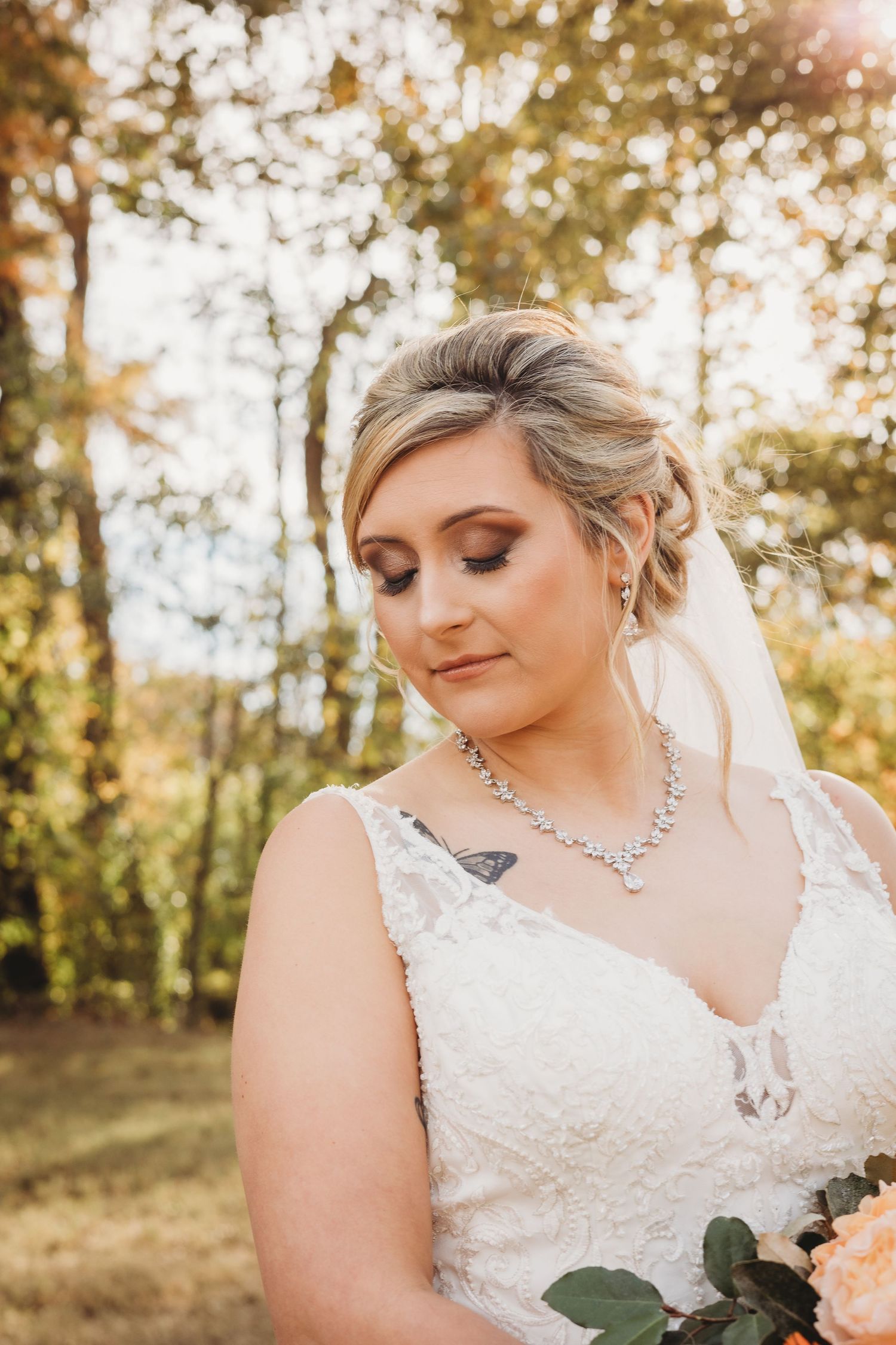 Detailed bridal photography highlighting sparkly jewelry and romantic makeup in golden hour light.