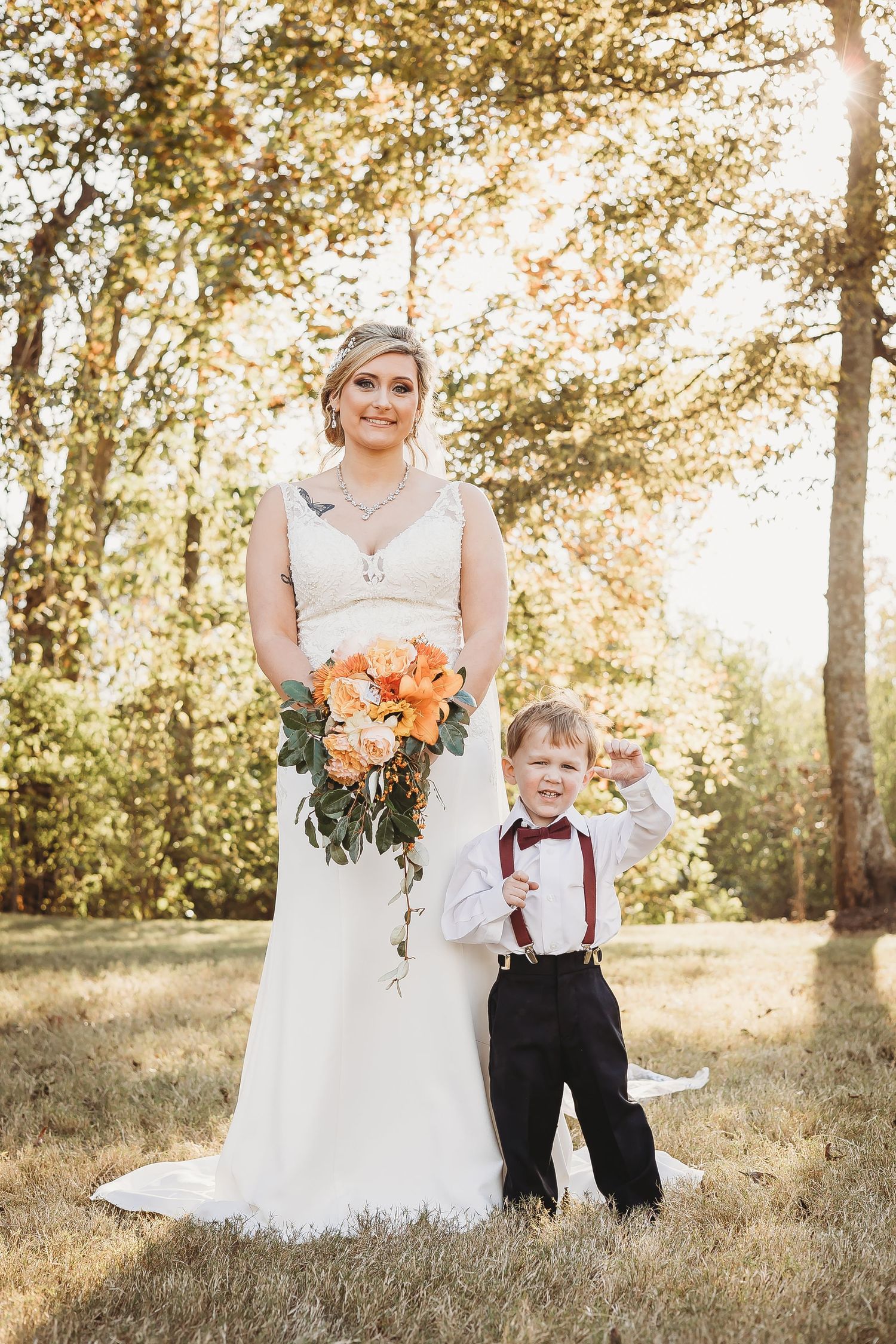 Wedding portraits featuring toddler in suspenders with bride in autumn outdoor setting.
