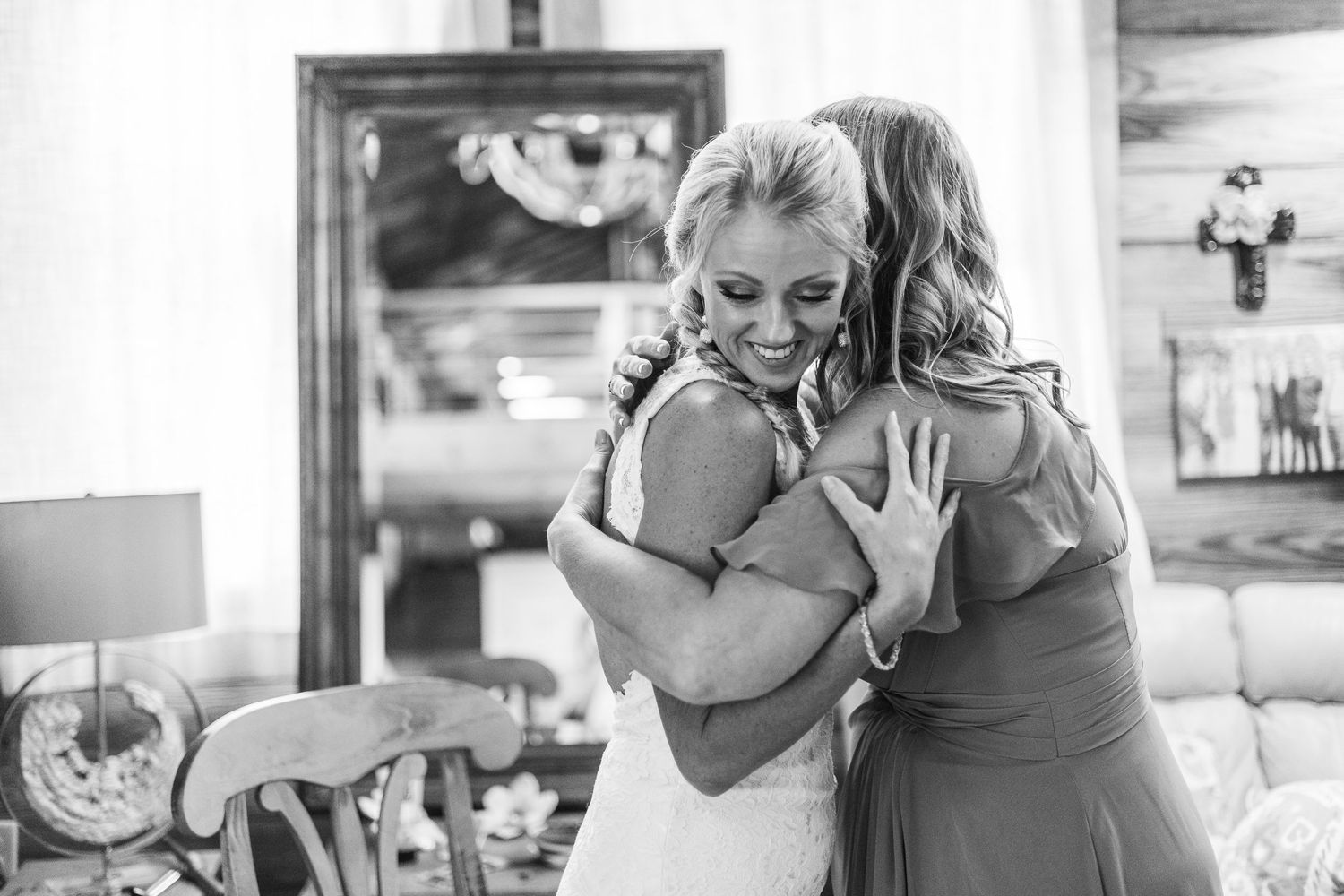 An emotional embrace captured in black and white during wedding preparations.