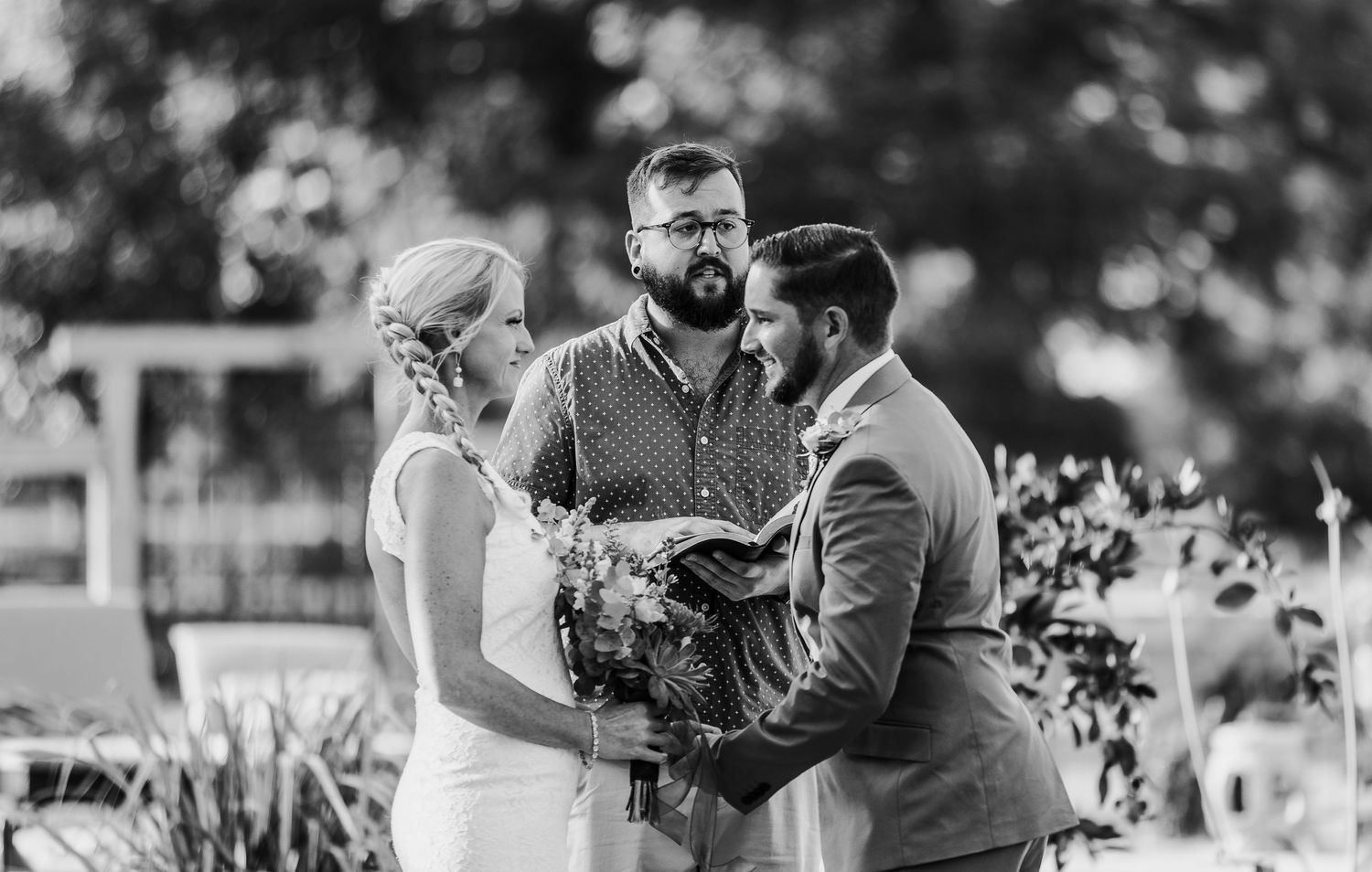 A black and white capture of an intimate outdoor wedding ceremony.