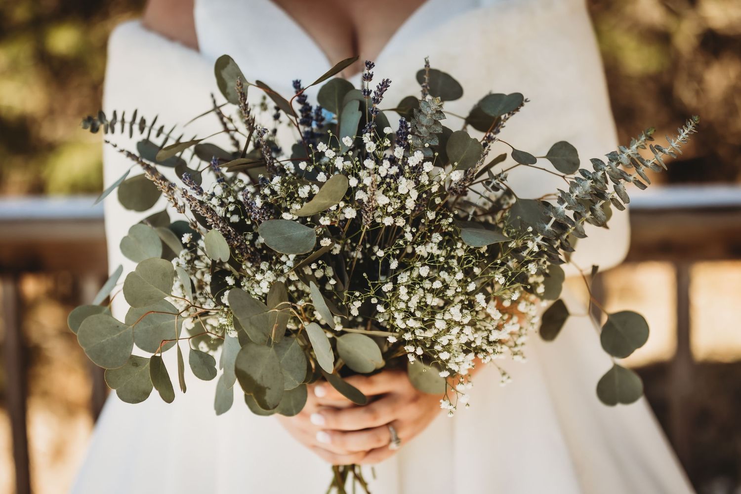 Sunlit wedding bouquet featuring fresh eucalyptus leaves and delicate baby's breath flowers.