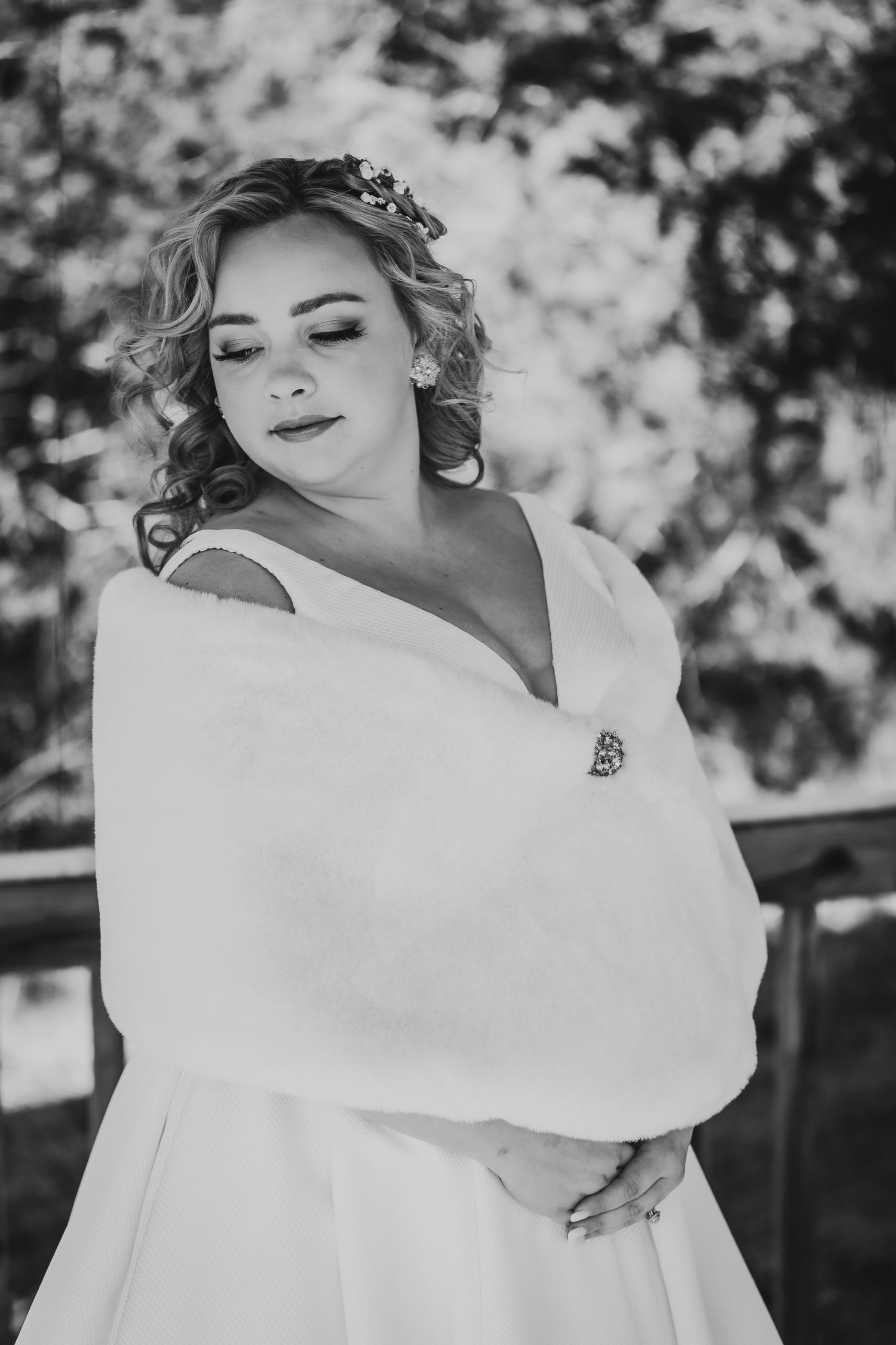 Black and white artistic bridal portrait showing elegant dress and wrap details.