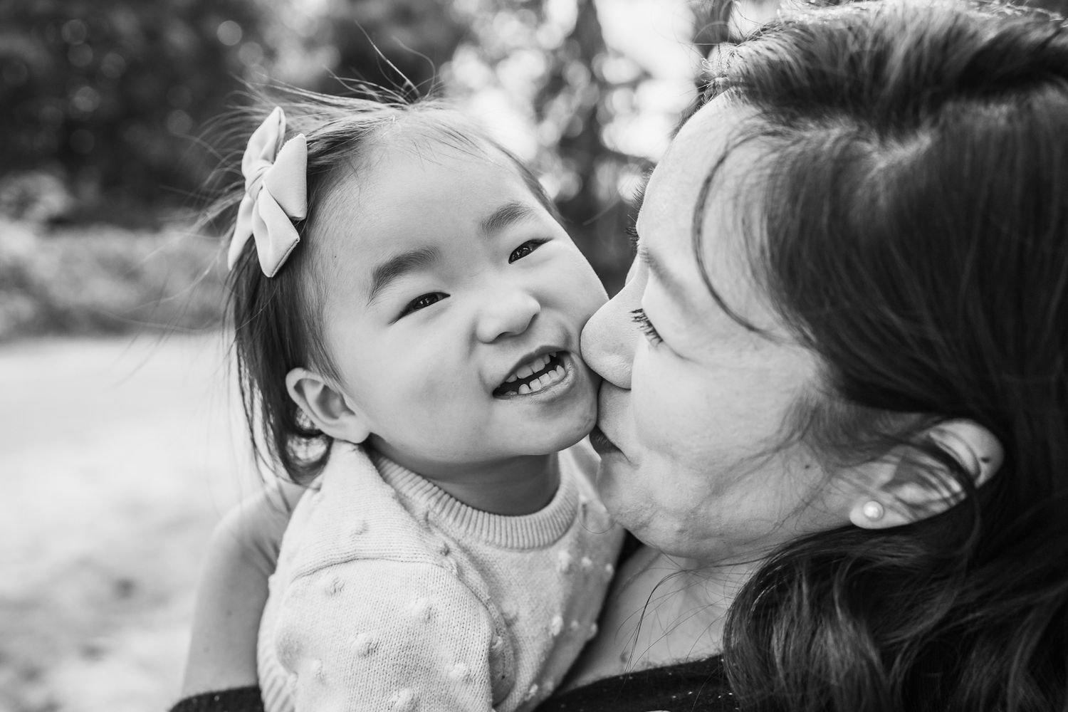 Seattle family photographer captures mother kissing daughter tenderly.