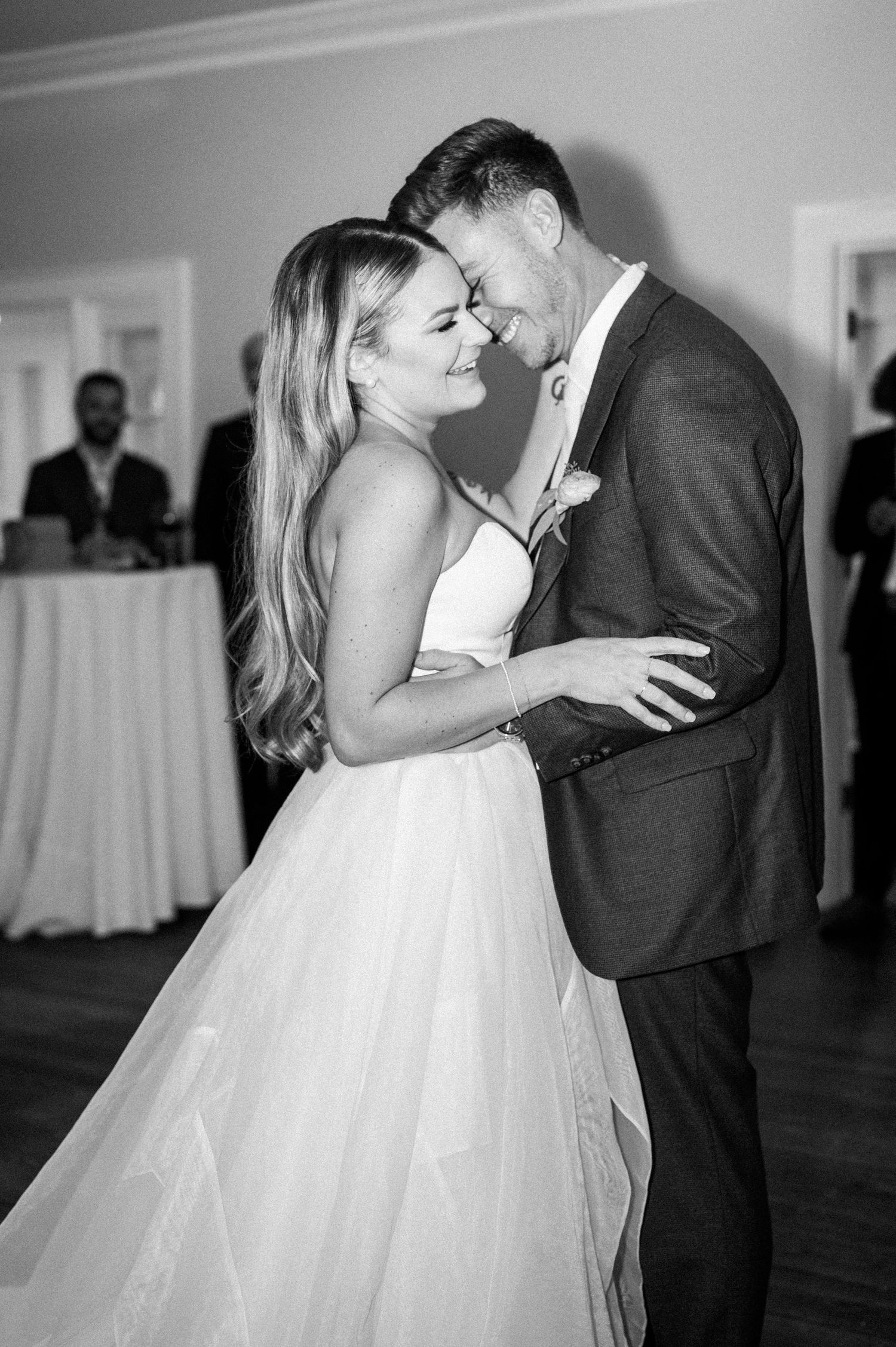 Black and white photo of newlyweds sharing a romantic dance moment.