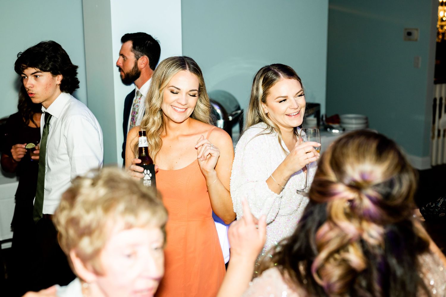 Party guests enjoying themselves on a dance floor with blue lighting.