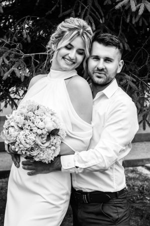 Black and white wedding photos showing couple with floral bouquet in garden setting.