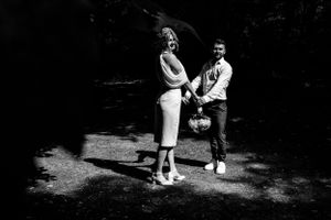 Black and white artistic photo of a couple in a wooded setting.