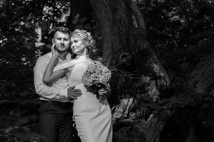 Dramatic black and white portrait of a couple in a wooded setting.