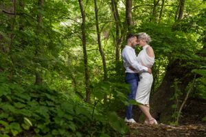 Romantic forest photography session with natural greenery backdrop.