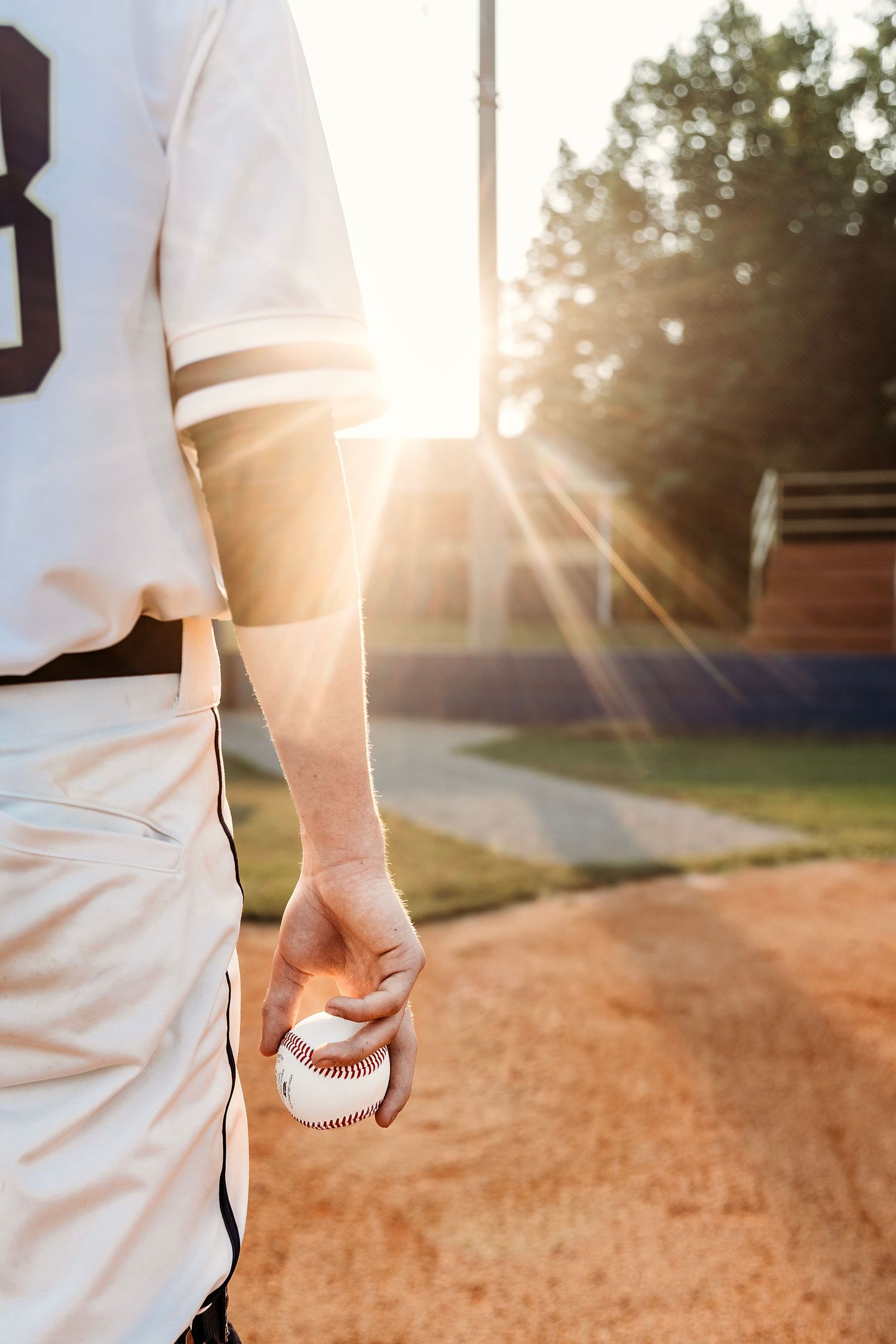 Close-up shots of baseball player holding ball at sunset. Middle TN senior photographer