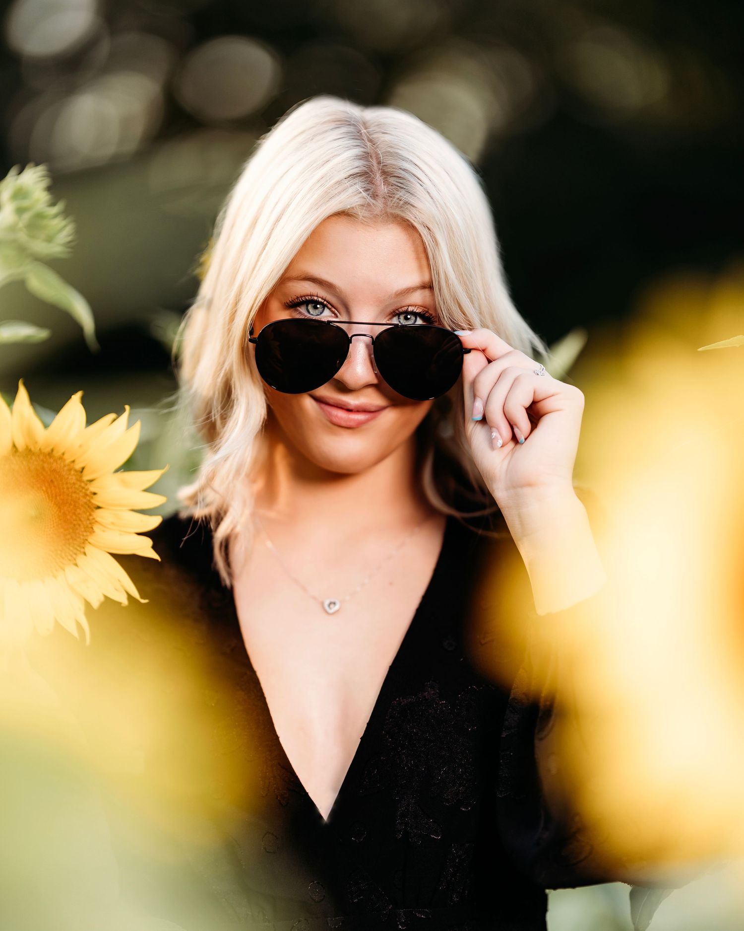 Summer portrait with sunflower and sunglasses against bokeh background. Middle TN senior photographer
