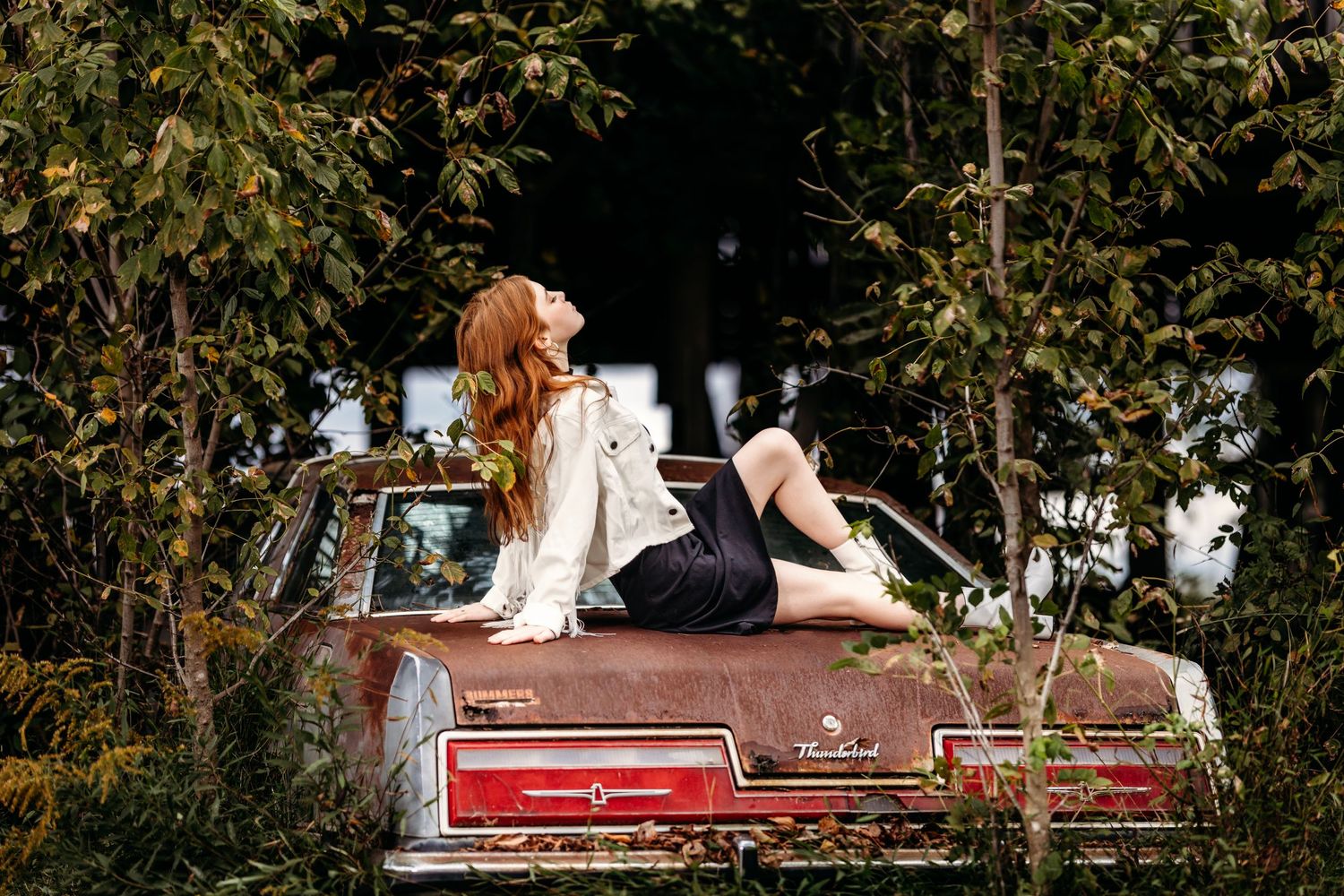 Artistic portraits on red vintage couch in natural outdoor setting. Middle TN senior photographer
