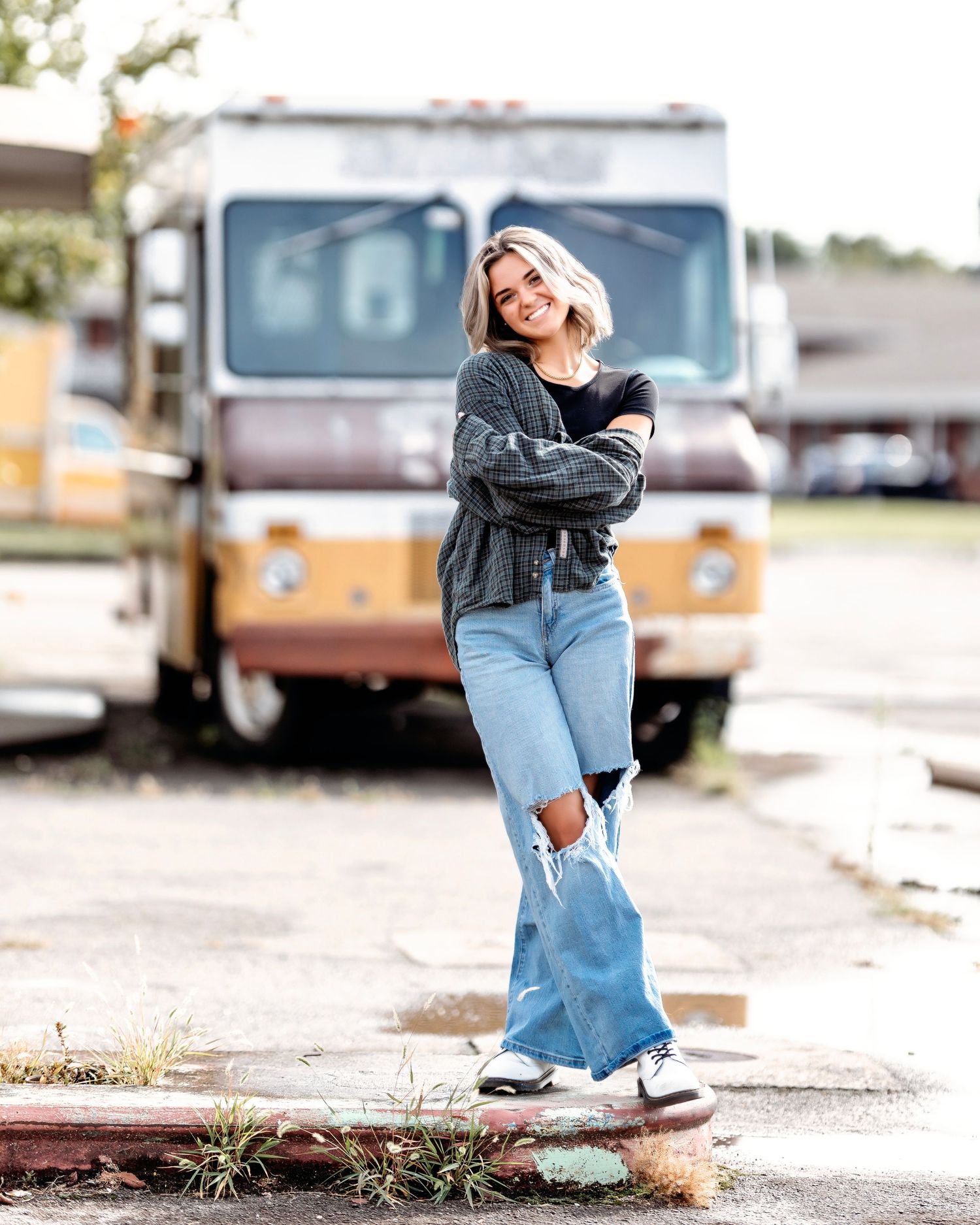 Clarksville Urban photoshoot featuring senior in  bell-bottom jeans against vintage RV background.  Middle TN senior photographer