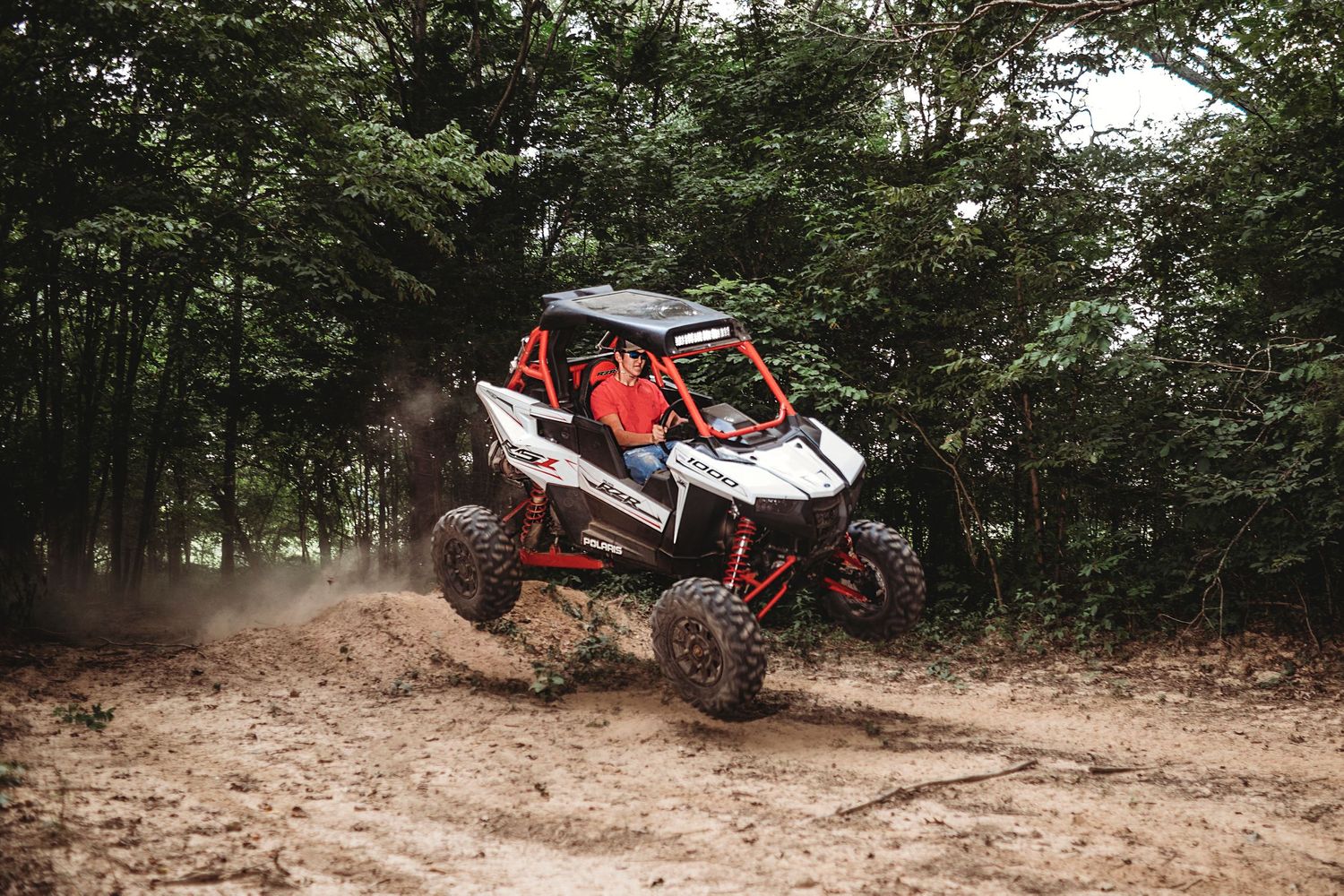 Action sequence of off-road vehicle jumping and navigating rough terrain through wooded area. Middle TN senior photographer