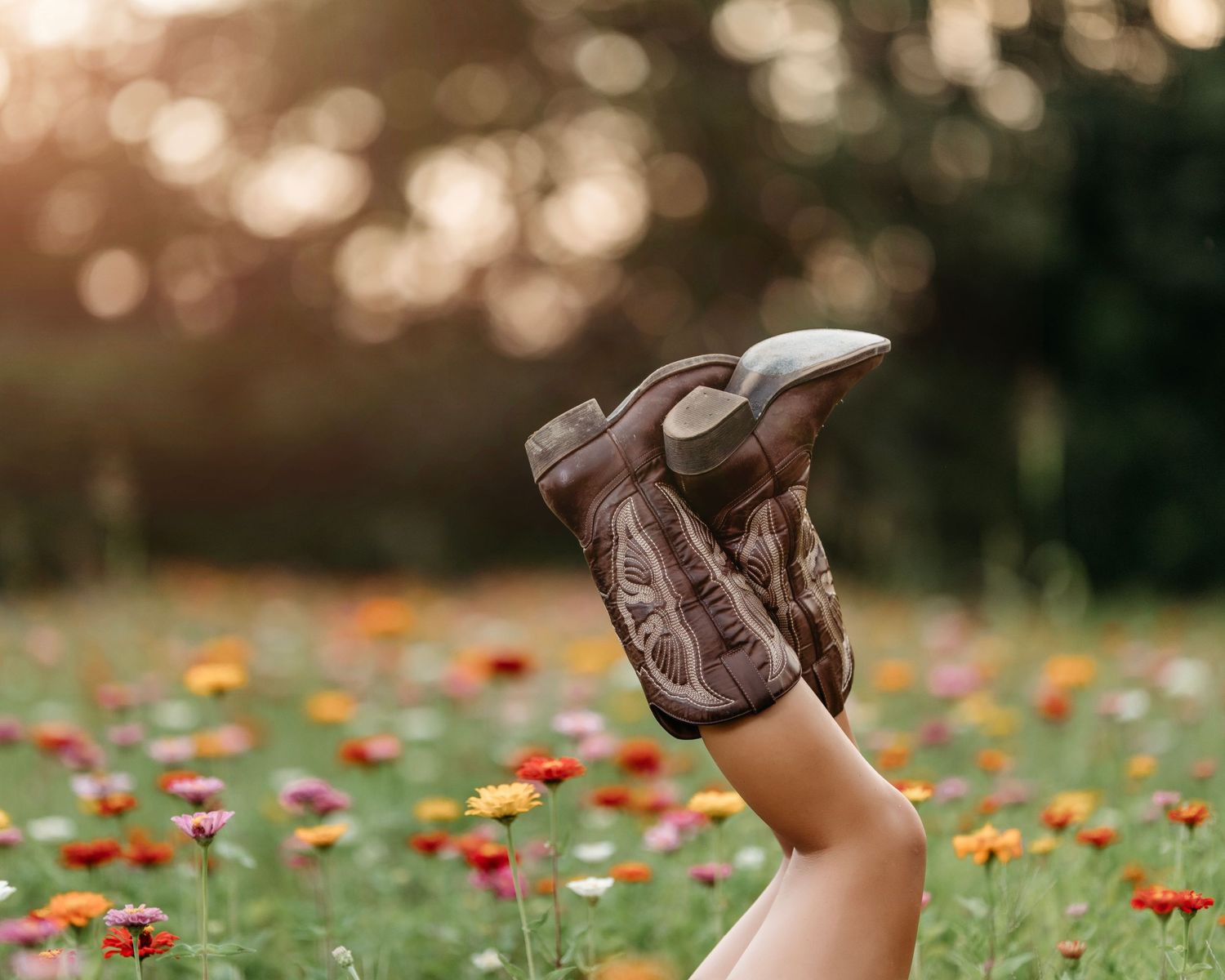 Brown boots floating against blurred autumn background with colorful flowers. Middle TN senior photographer
