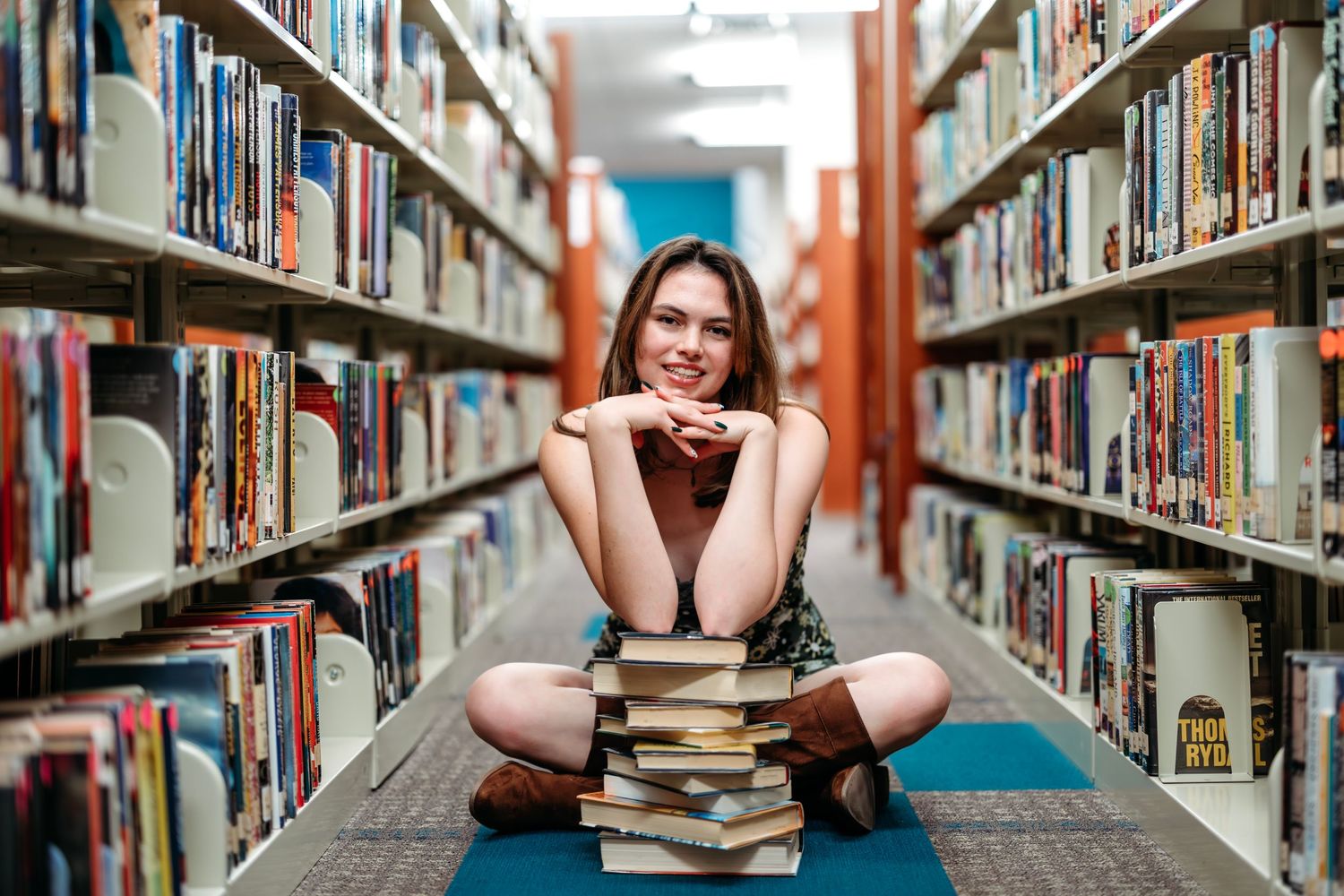 Series of photos showing senior studying between bookshelves in a library.  Middle TN senior photographer