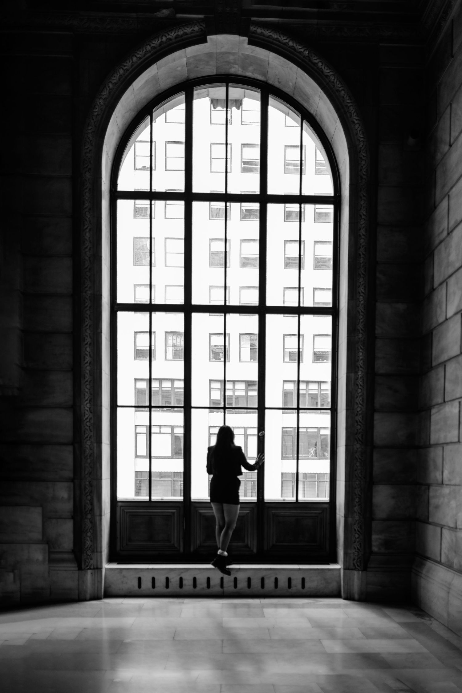 Black and white NYC architectural senior showing silhouettes against arched windows. Destination senior photographer