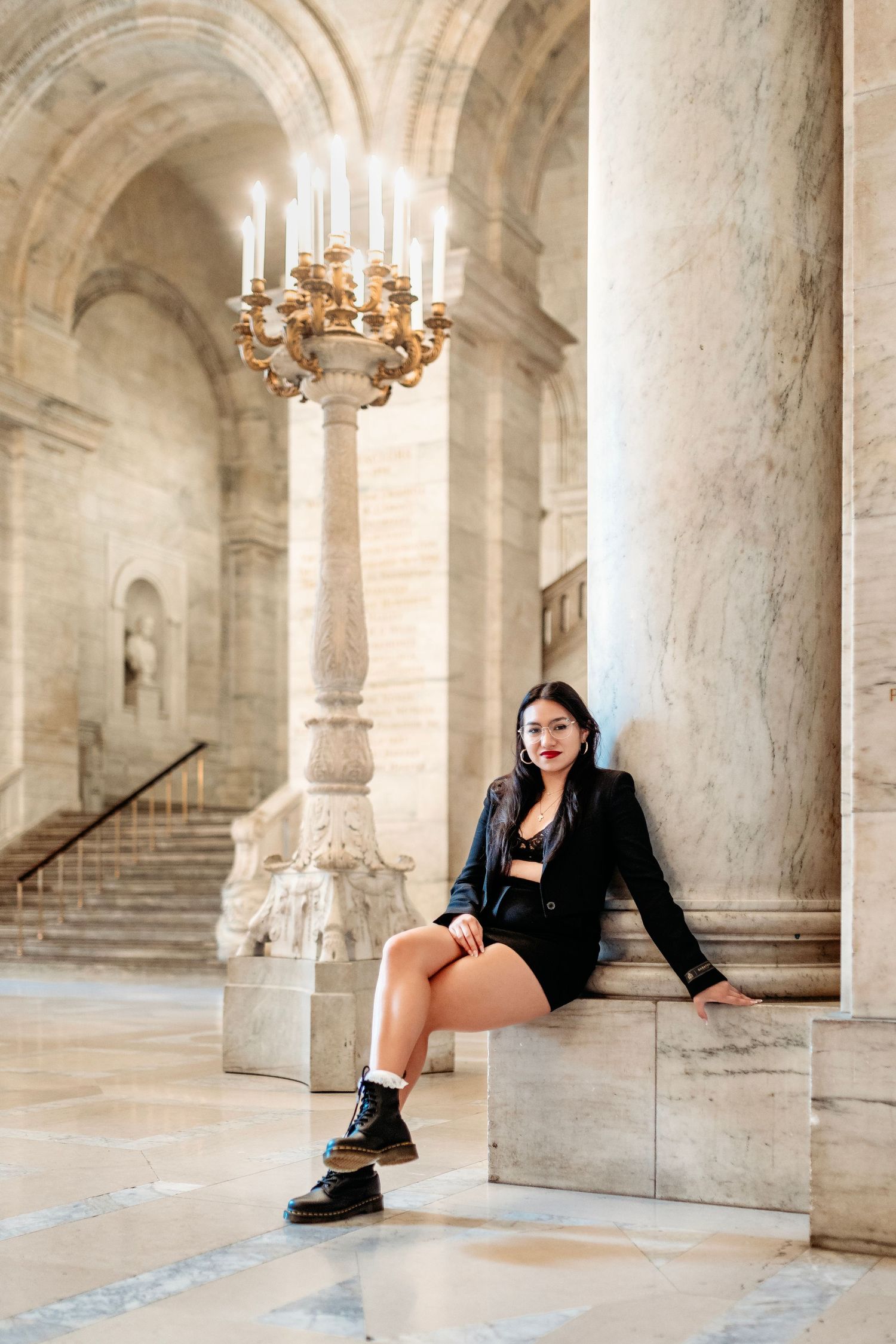 Architectural photoshoot in NYC elegant marble hallway with chandeliers and classical columns. Destination senior photographer