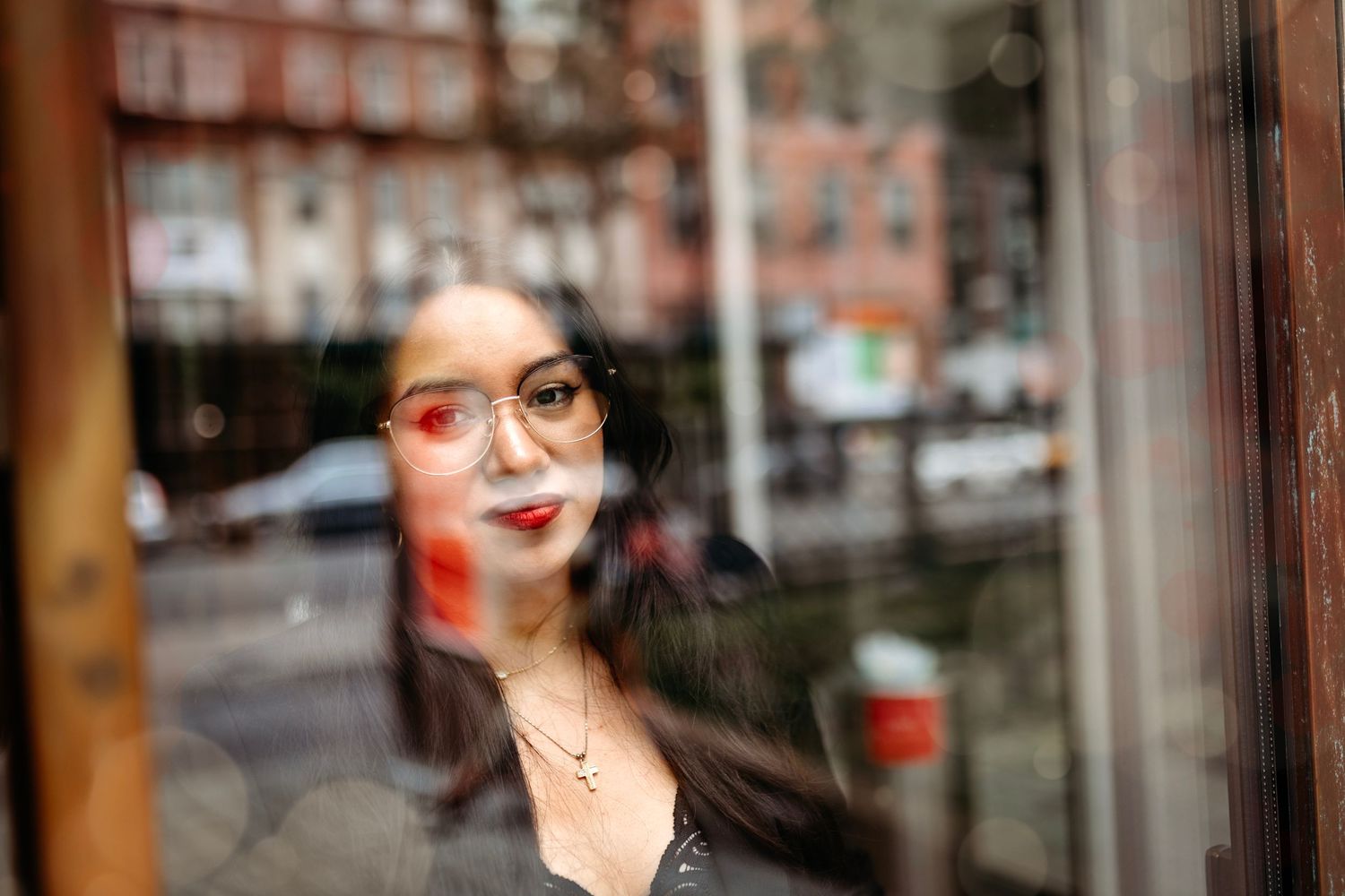 NYC Urban portrait series through window reflections in city setting. Destination senior photographer