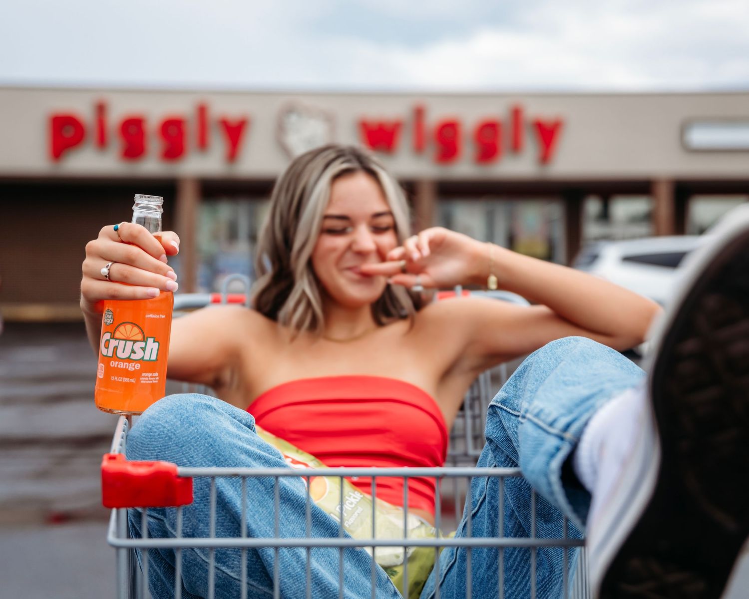 Casual lifestyle portrait in shopping cart with orange soda can. Middle TN senior photographer