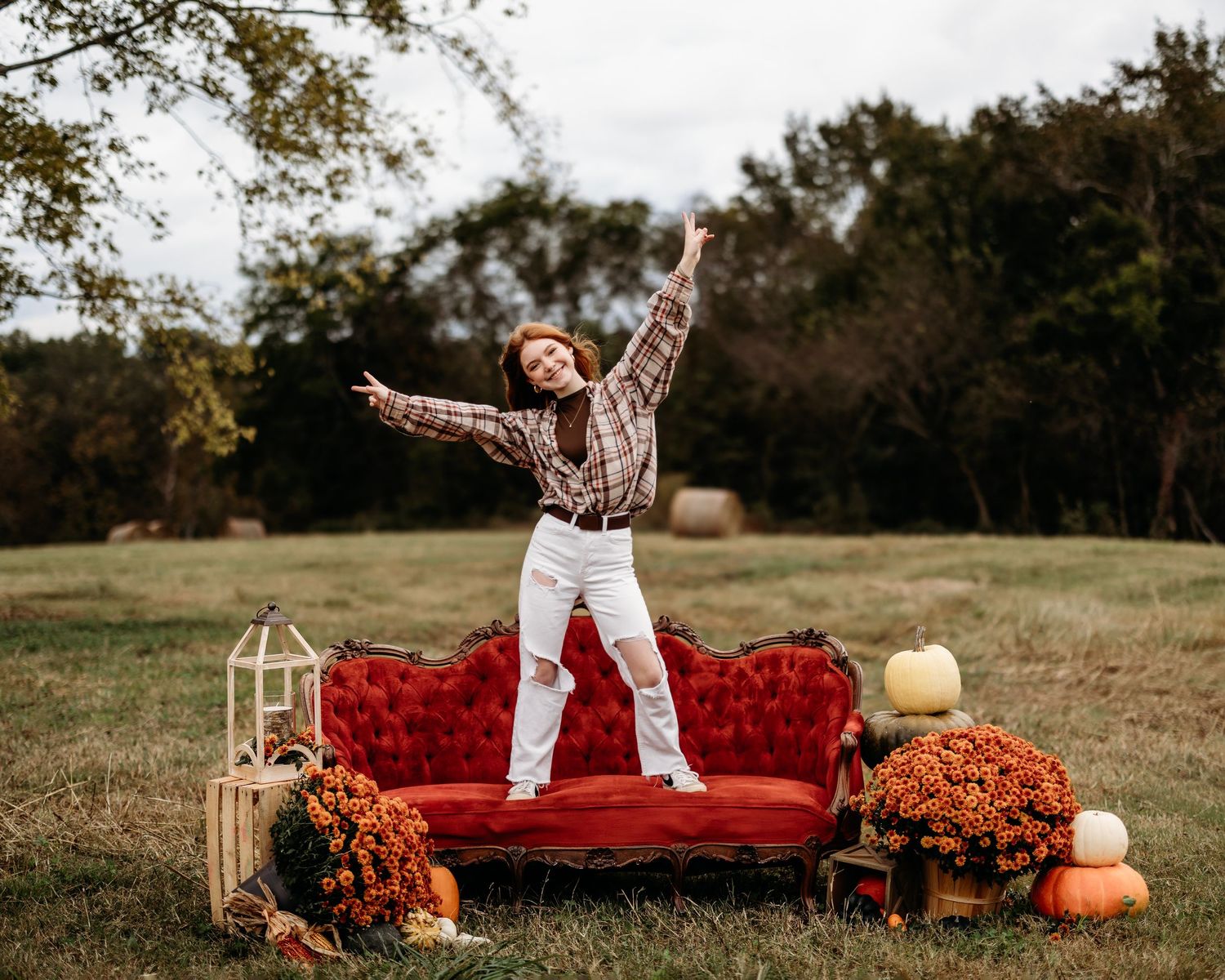 Outdoor photo session with red vintage couch and fall decorations. Middle TN senior photographer