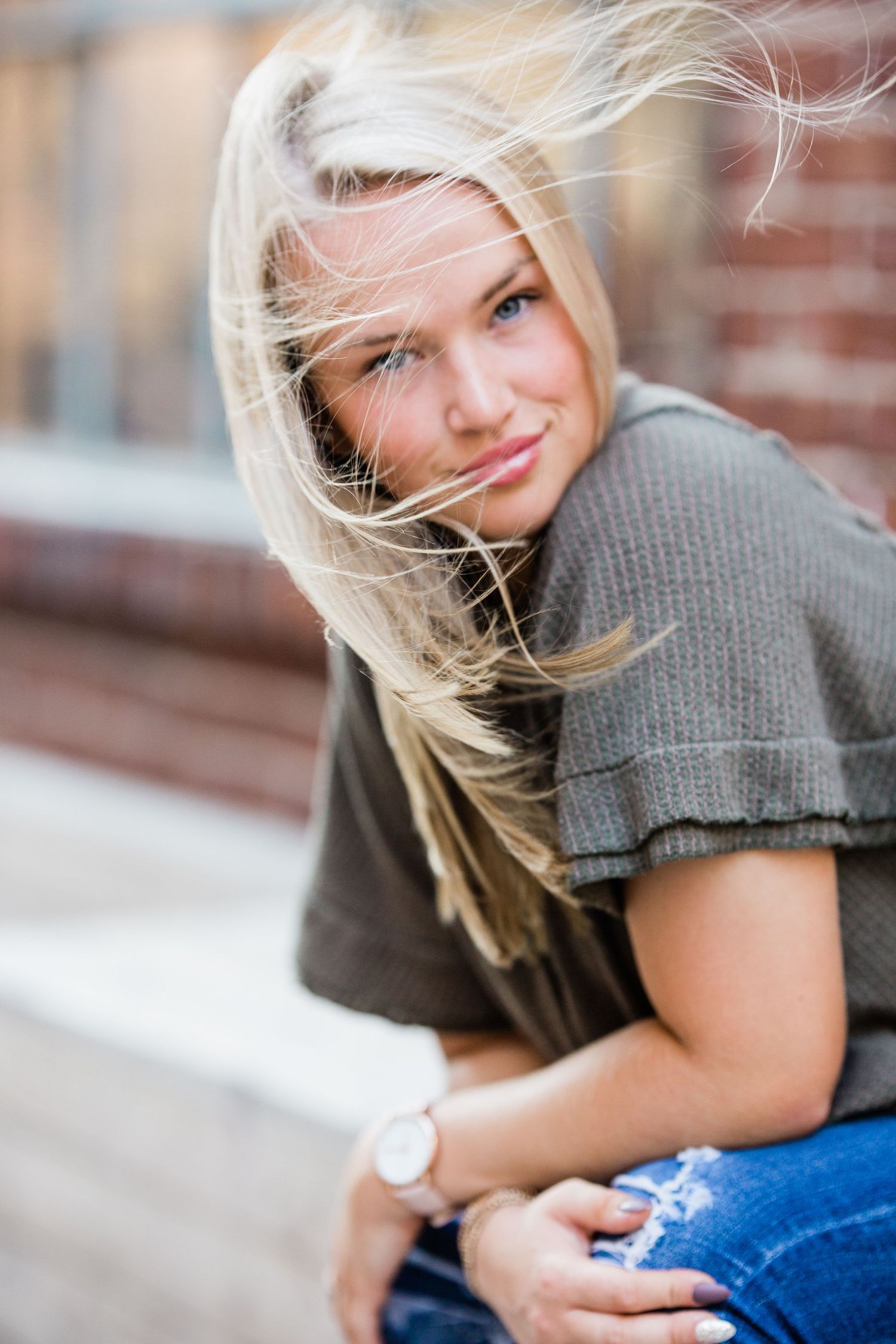 Portrait sequence showing blonde hair blowing in the wind against a brick wall background. Middle TN senior photographer
