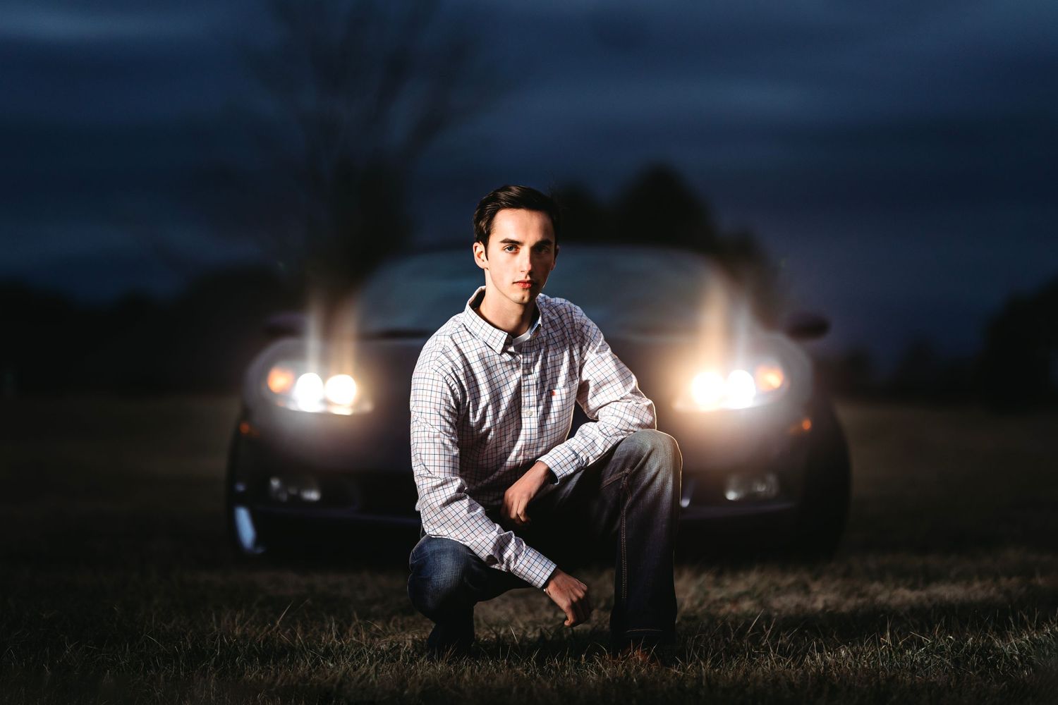 Dramatic nighttime portrait with car headlights creating atmospheric lighting.  Middle TN senior photographer