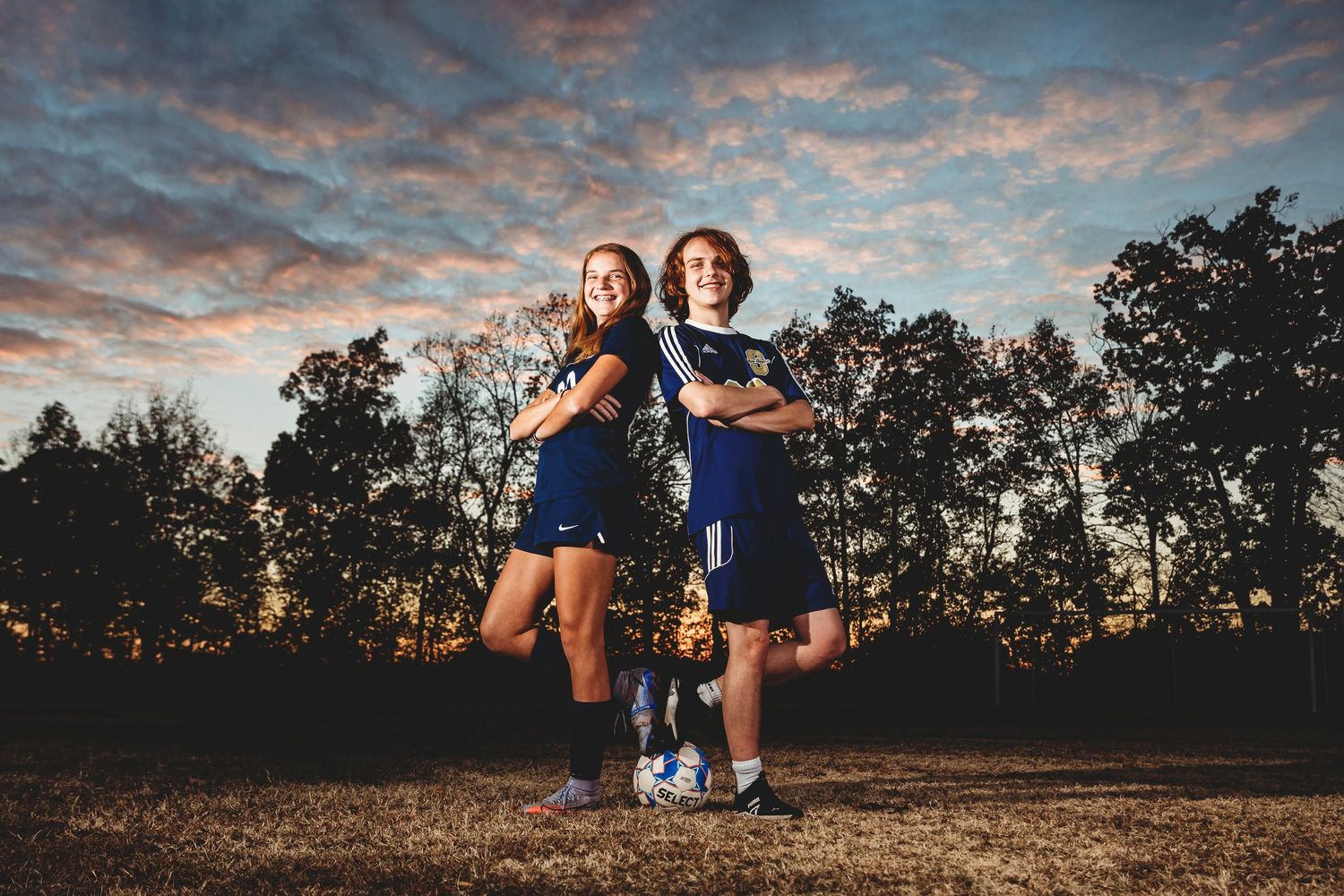 Athletes silhouetted against vibrant sunset sky in outdoor sports setting. Middle TN senior photographer