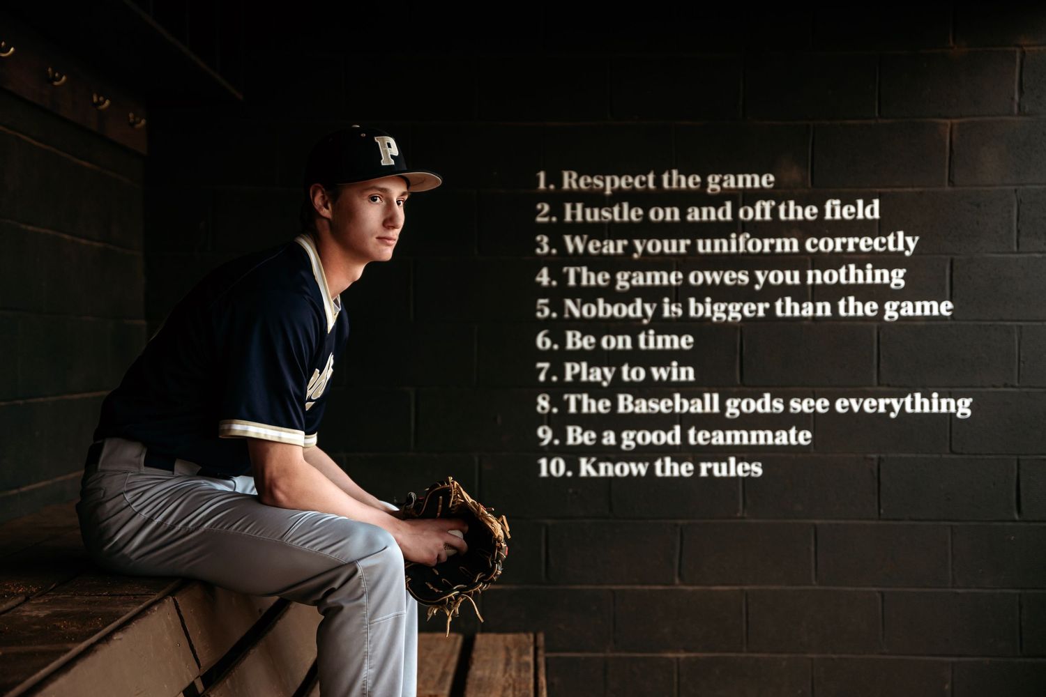 Baseball rules and guidelines displayed on dark wall with moody lighting. Middle TN senior photographer